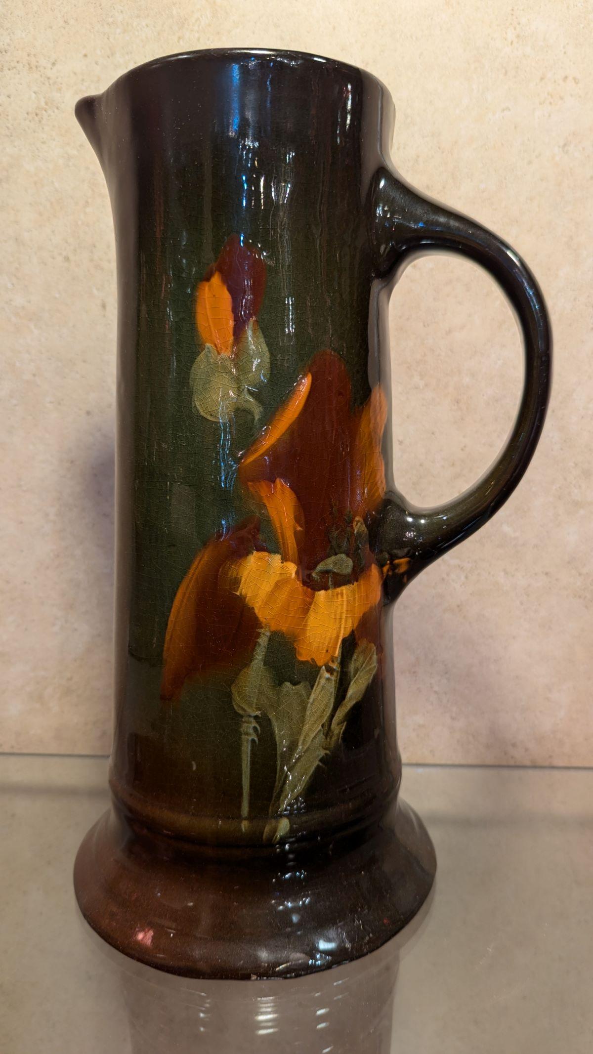 Schöner Jugendstilkrug von Weller, dunkel- bis mittelglänzend braun mit orangegelbem Blumenmotiv, Henkel und Ausguss