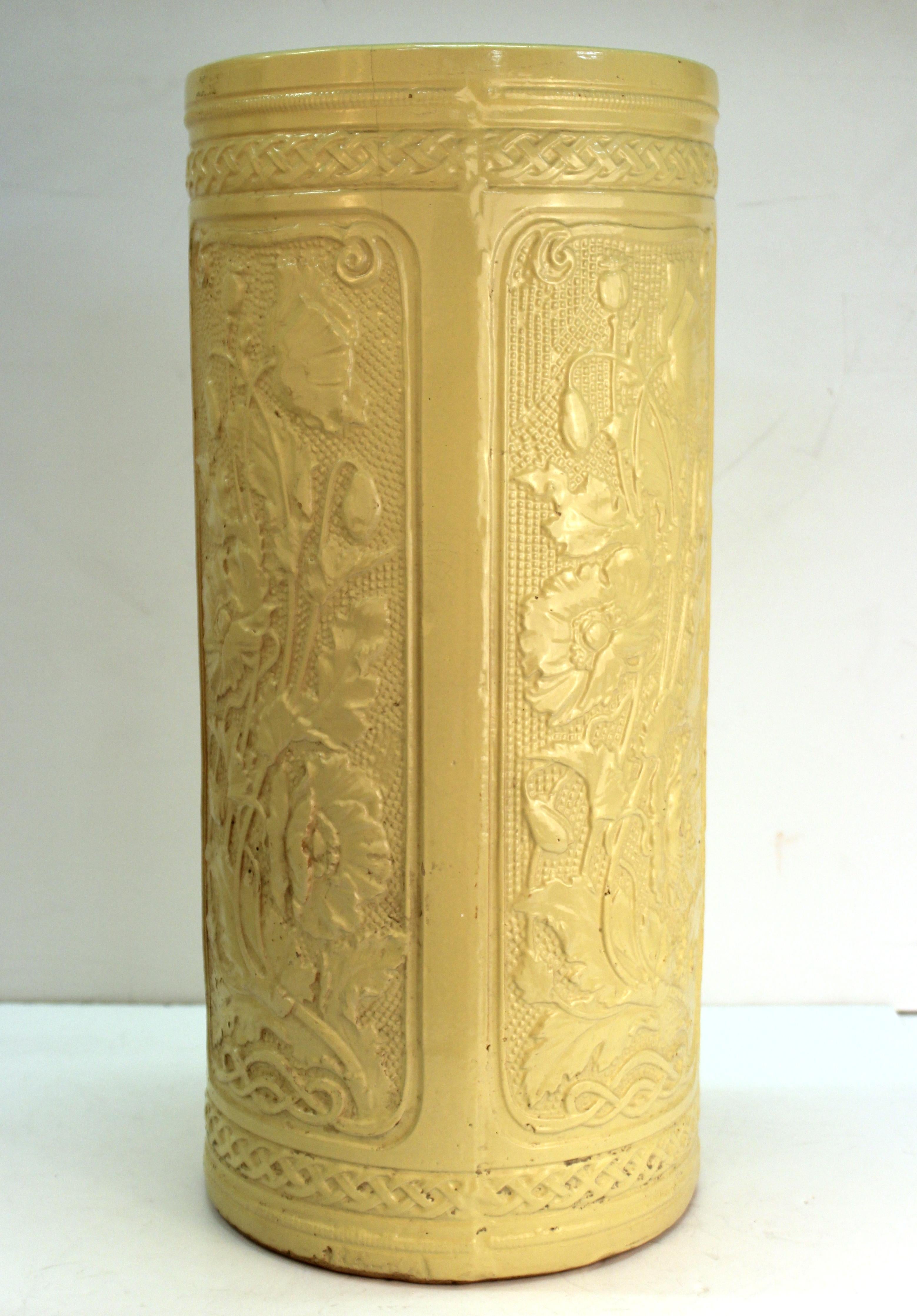 American Art Nouveau period umbrella stand or cane holder created by Weller Pottery during the turn of the century in cream colored pottery with a raised 'Poppy' floral relief motif. The piece is in great vintage condition with age-appropriate wear.