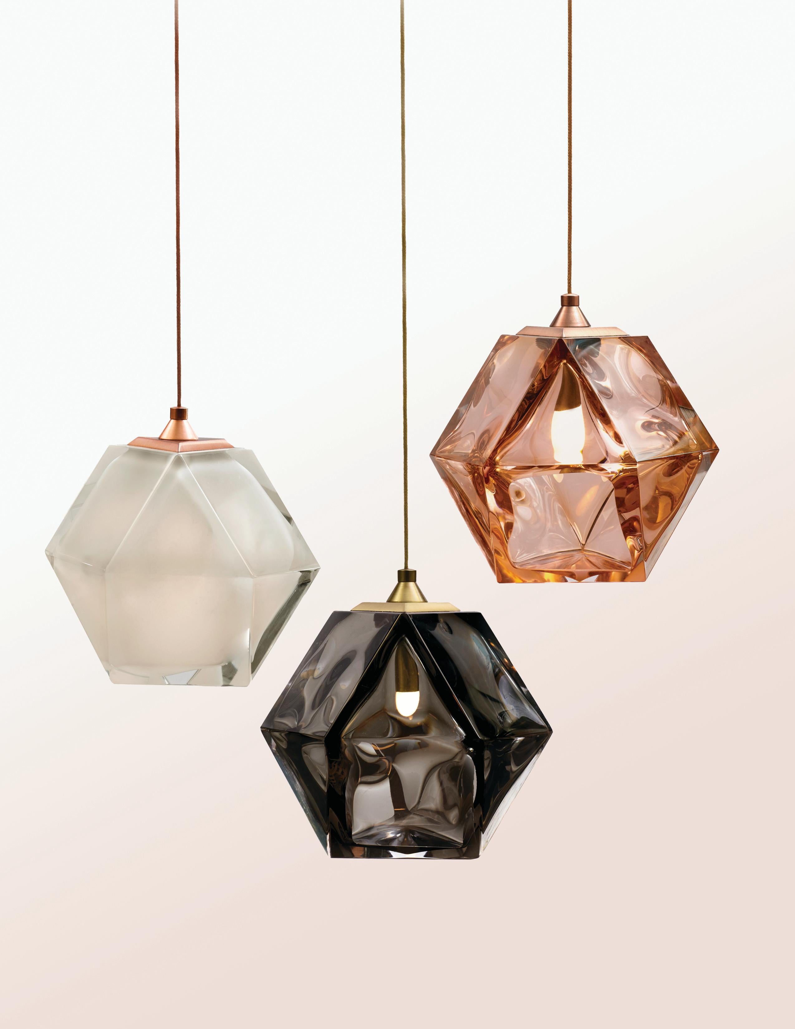 Single gem-like pendants hung from a finely braided metallic-cable, reminiscent of custom crafted jewelry, these exquisite pieces are available in smoked-gray, Alabaster-White and California-pink glass. The welles silhouette is created through an