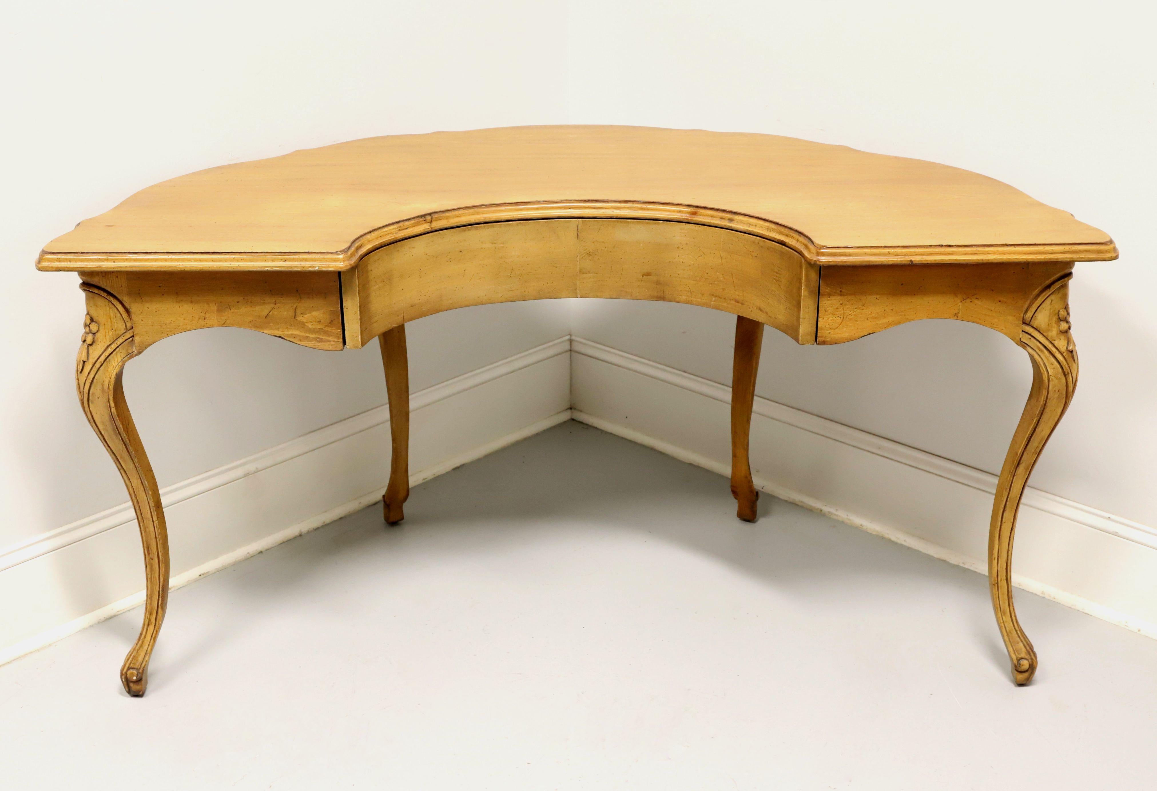 A French country style half circle writing desk by Wellesley Guild. Hand carved and crafted of walnut with a distressed finish, serpentine shaped smooth surface top with an ogee edge, decoratively carved outward facing apron, carved knees, curved