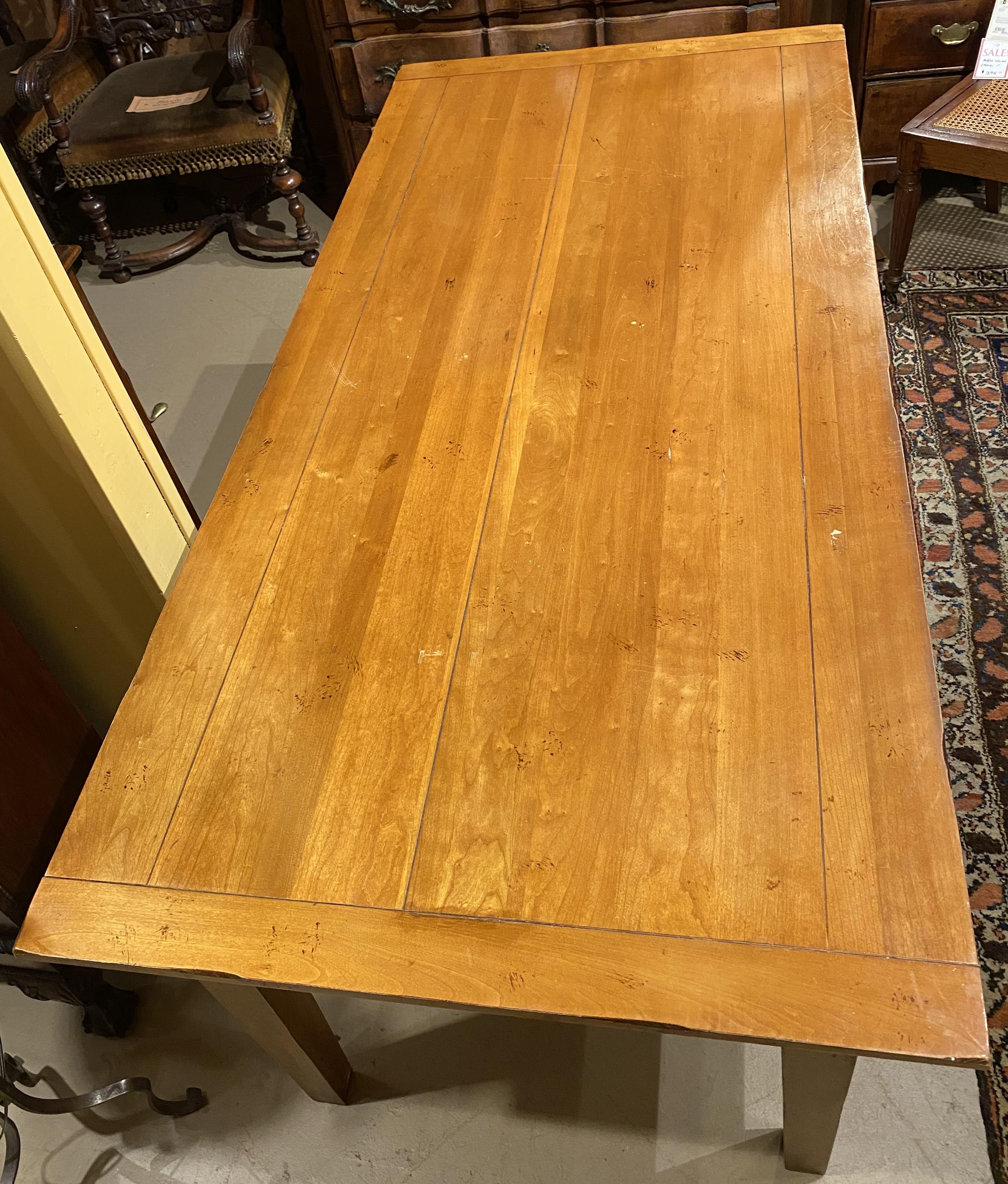 A fine cherry rectangular farm table with breadboard ends and tapered square legs. This solid farm table is in very good condition, with minor surface stains, scratches, light edge wear and other imperfections and wear commensurate with age and use.