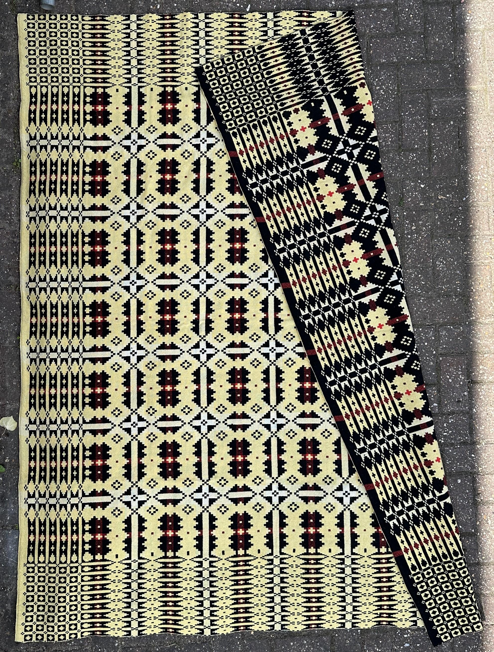 Tradicional manta Welch de los años 50 - Aur Cymru en galés, famosa por sus fuertes motivos regionales, diseño del baluarte de Caernarfon, tejida a mano con trama negra y urdimbre blanca y crema con detalles rojos. Cada manta Welch es única. La