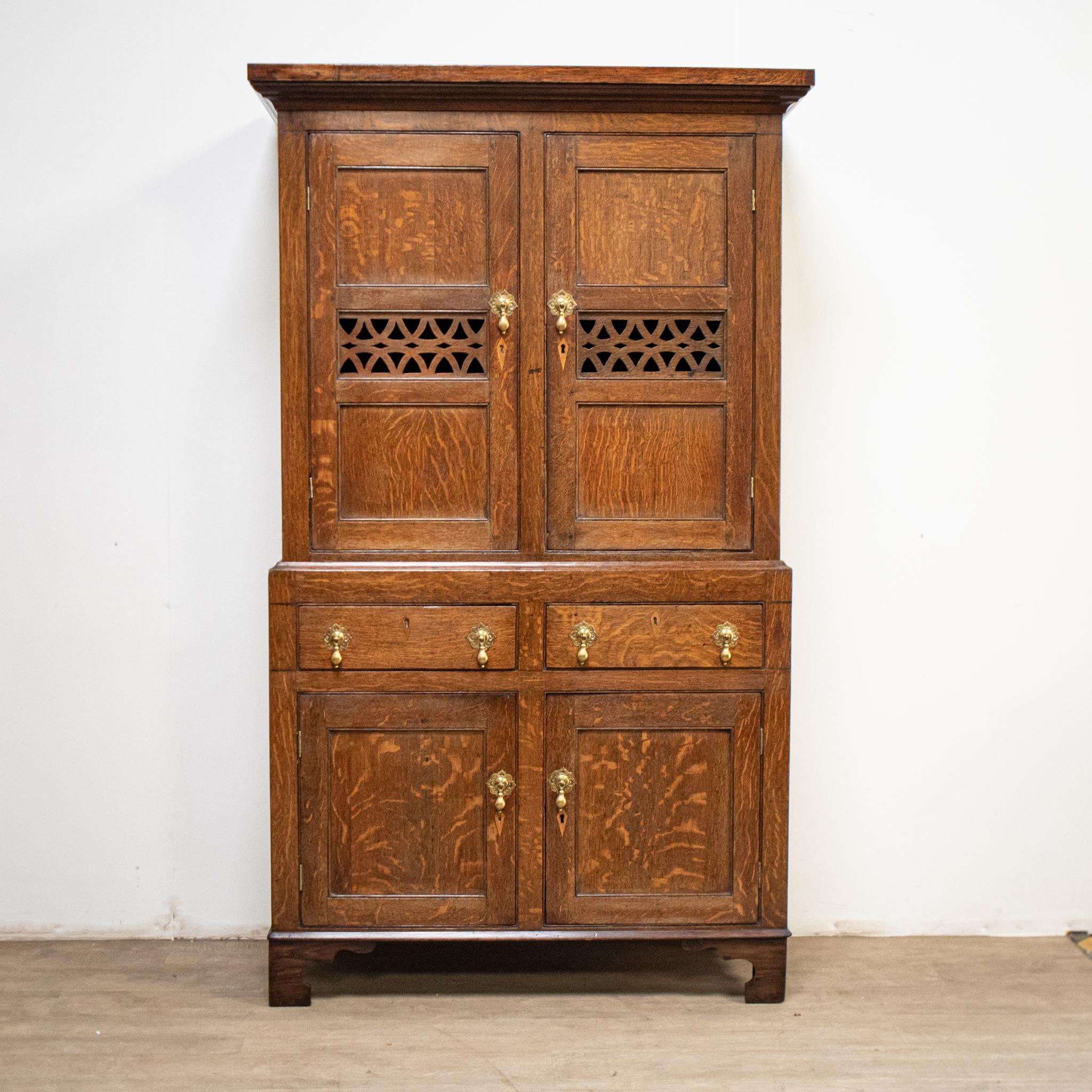 This beautiful early 19th century oak food cupboard has the traditional decorative fretwork panels in the upper section allowing ventilation into the storage area, which has two shelves. The piece separates into two for ease of moving.
With a superb