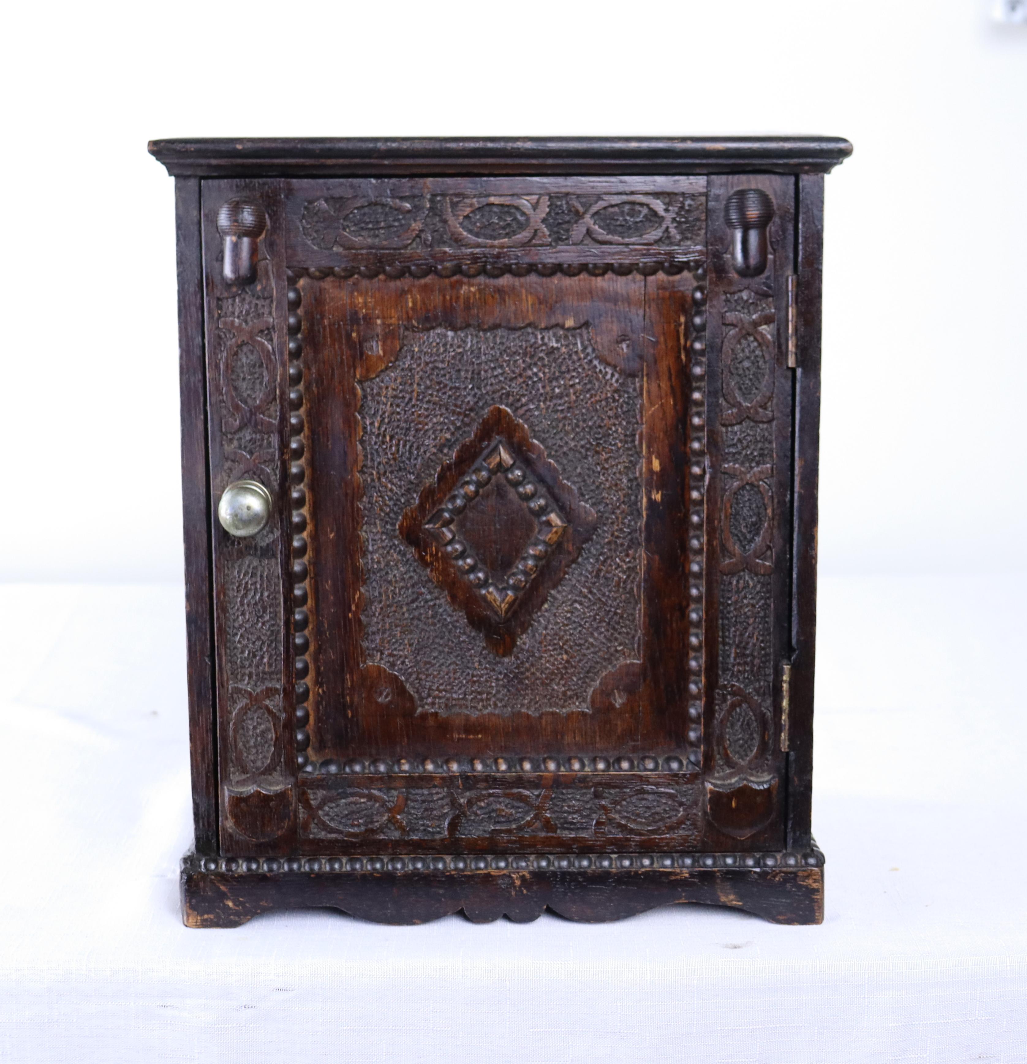 An intricately carved antique Welsh medicine cabinet with a small charming drawer on the inside. Can easily be wall mounted or used as is.