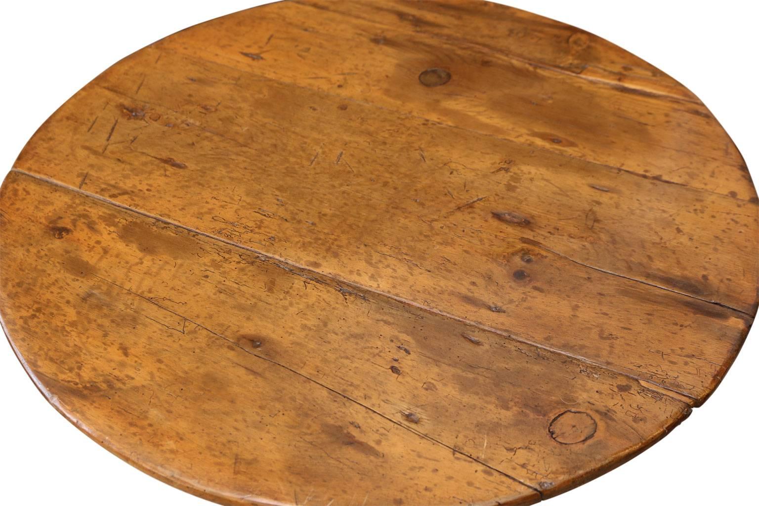 Welsh cricket table: pine top and brown painted base (original or very old paint). Its under-tray shelf supports are scalloped and its legs feature carved rounded edges and are tapered at the feet. This larger than average, charming cricket table is
