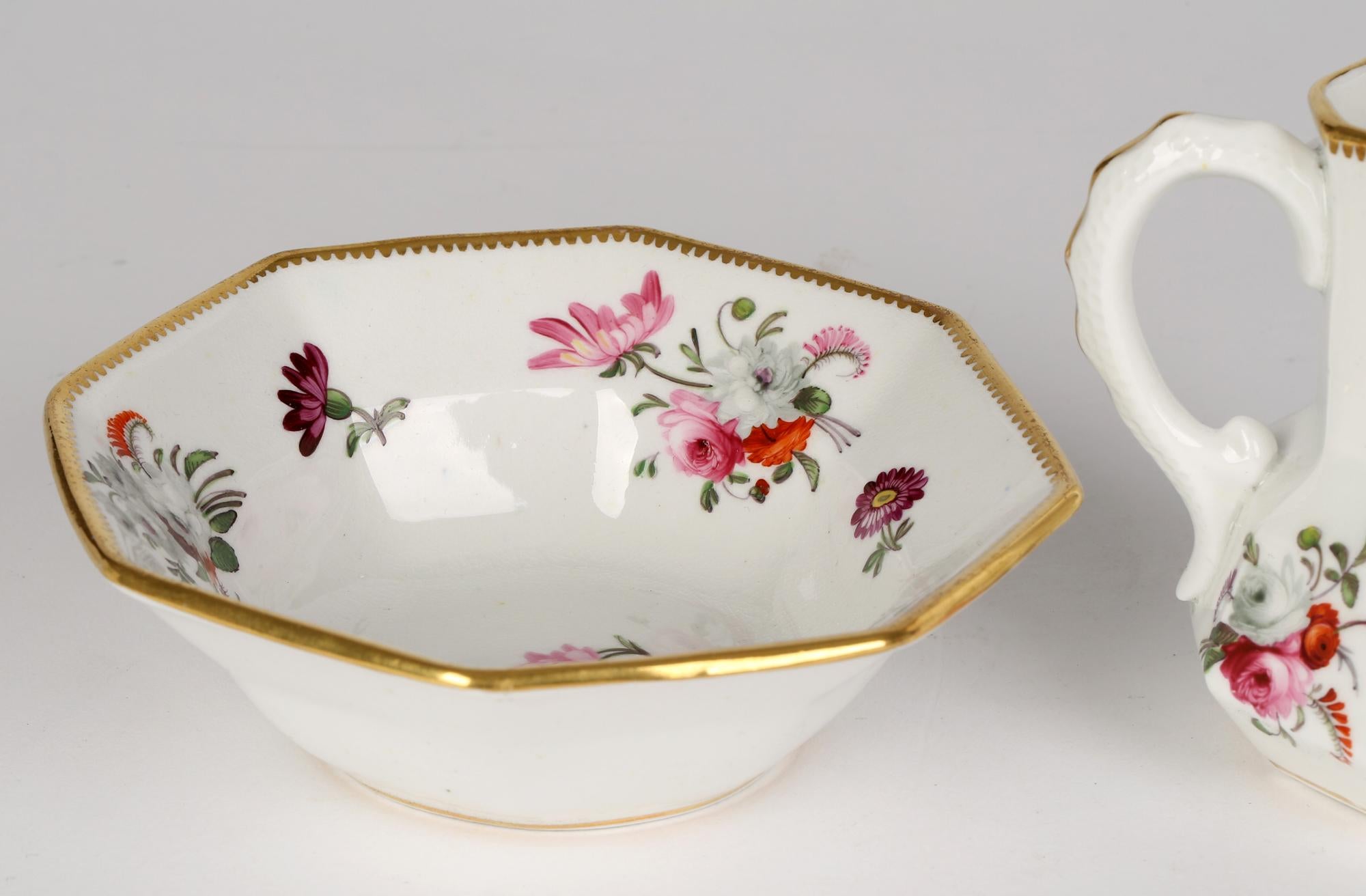 Jarra antigua de porcelana con asa de serpiente, pintada con motivos florales, galesa o inglesa, de principios del siglo XIX. El conjunto consta de una jarra de forma hexagonal pintada a mano con diseños florales y con el borde dorado. El soporte