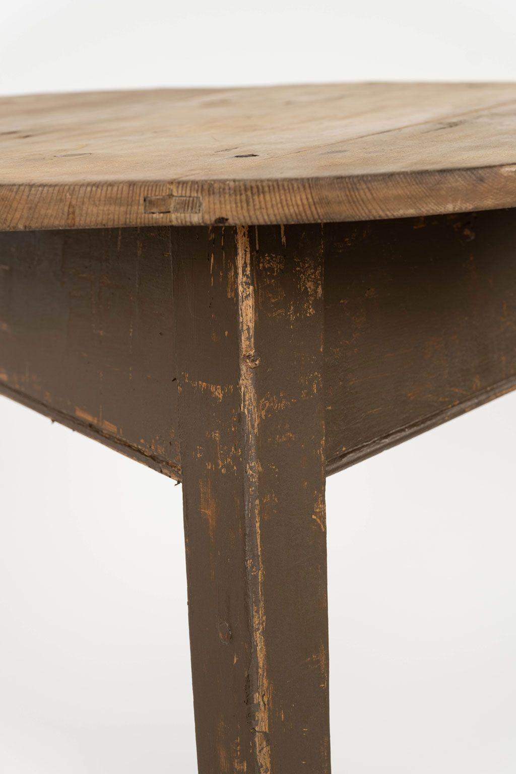 Welsh scrubbed-top cricket table circa 1830-1859. Round scrubbed top upon brown-painted base. Three tapered legs. Hand-carved in pine with mortise and tenon joined construction.