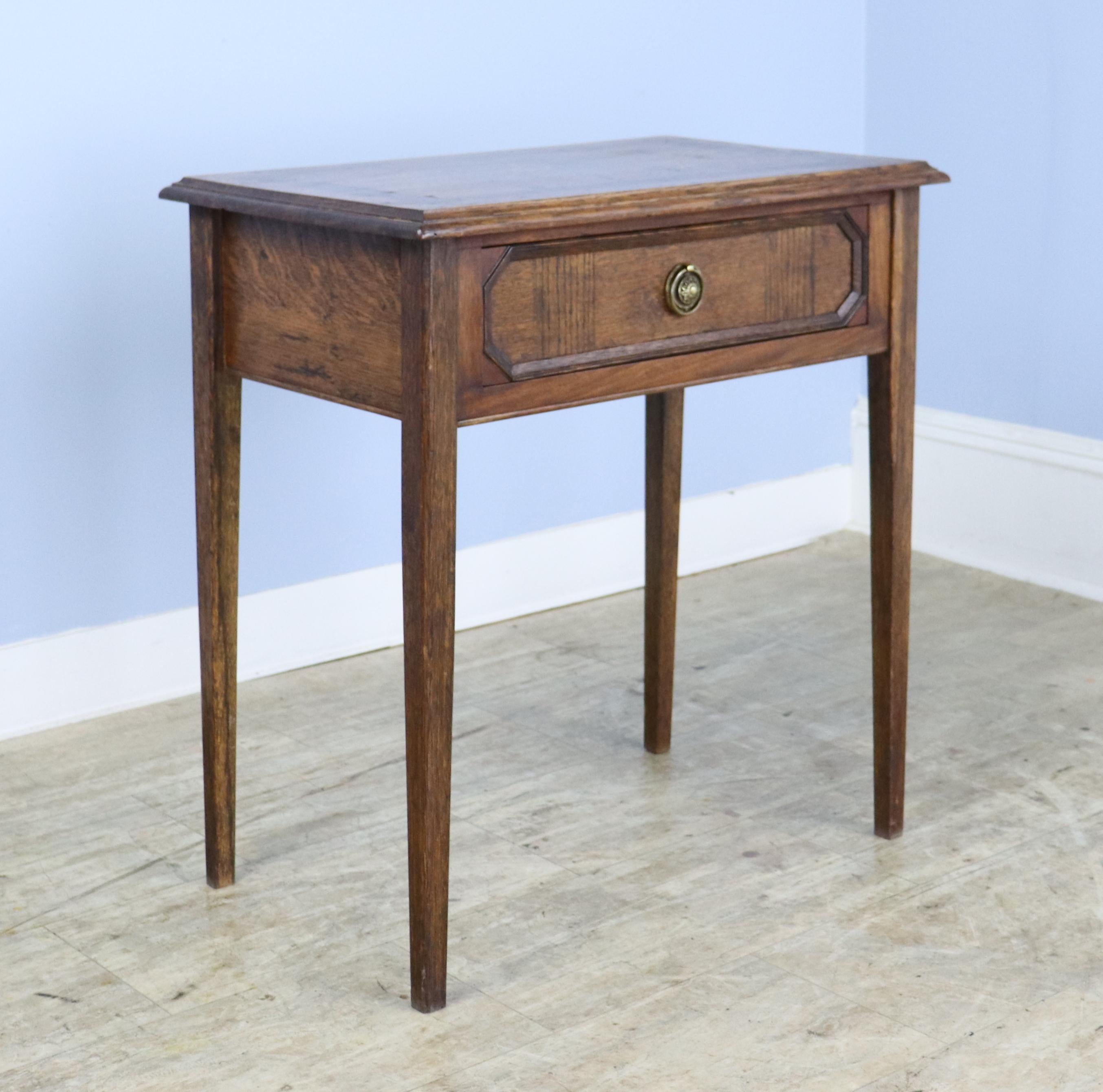 A small oak side table with vibrant grain and excellent mahogany inlay.  The piece is very sturdy and well made, with good mouldings on the top and inset panel on the drawer front.  Drawer interior is clean.  Very good patina and all in all quite