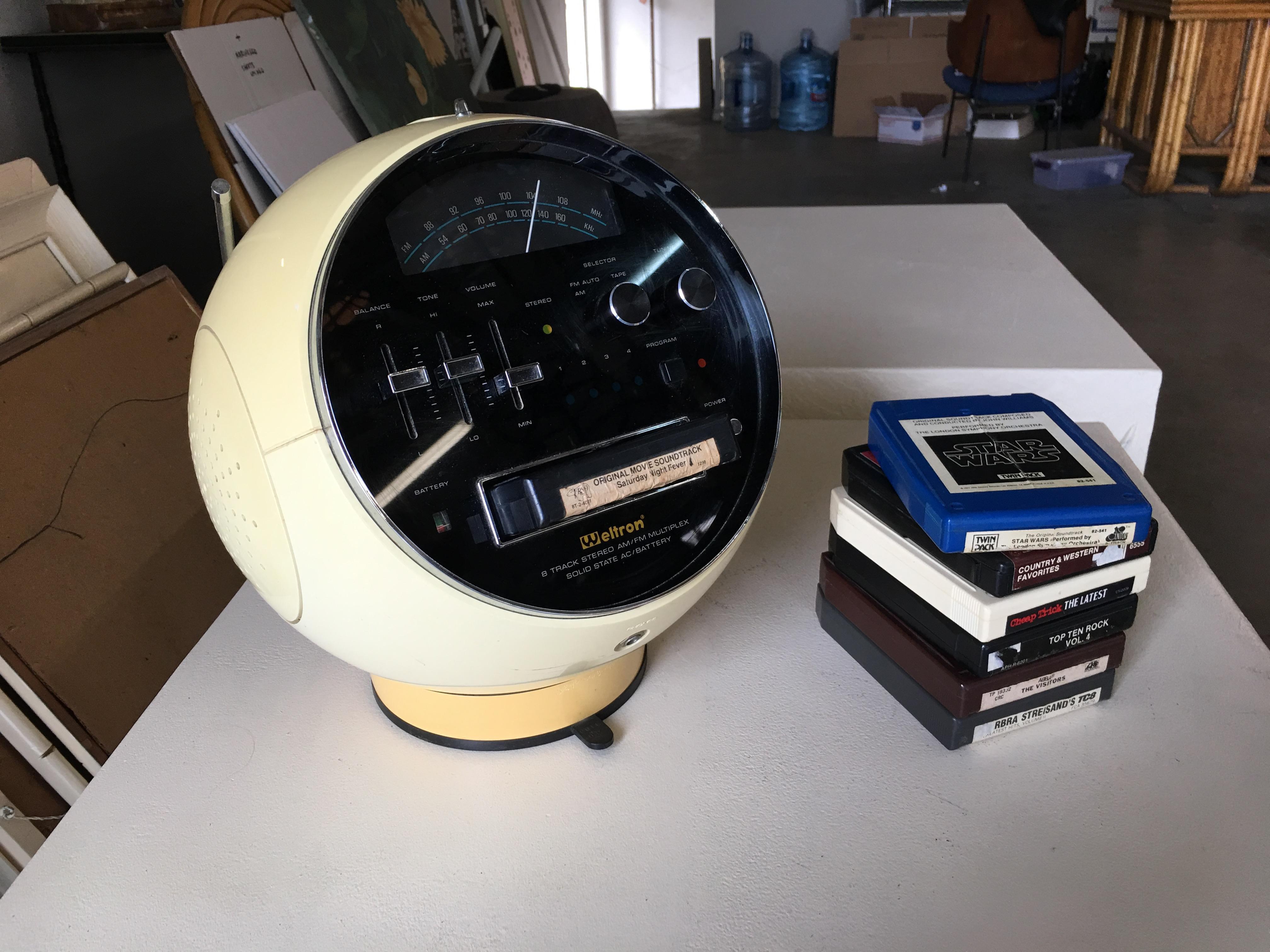 Fully functioning ultra-modern model 2001 space ball AM/FM stereo with 8 track player. This rare unit was produced by Weltron and features stereo sound with hidden top handle and swivels to any direction for easy operation. All 8 tracks pictured are