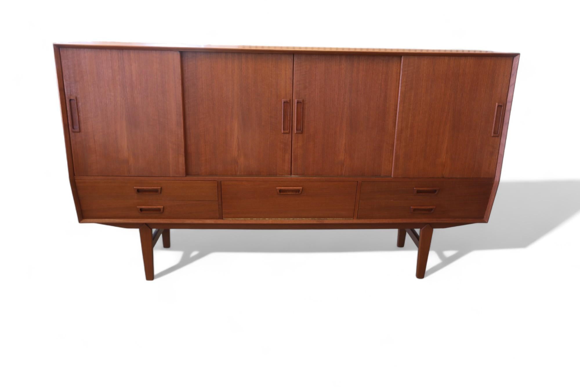 A fantastic Danish cabinet that has so many fine details that give the cabinet its stylish whole!

The cabinet is manufactured by Wemb Møbelfabrik and has a graded front with four sliding doors that have oval and integrated handles. Very practical