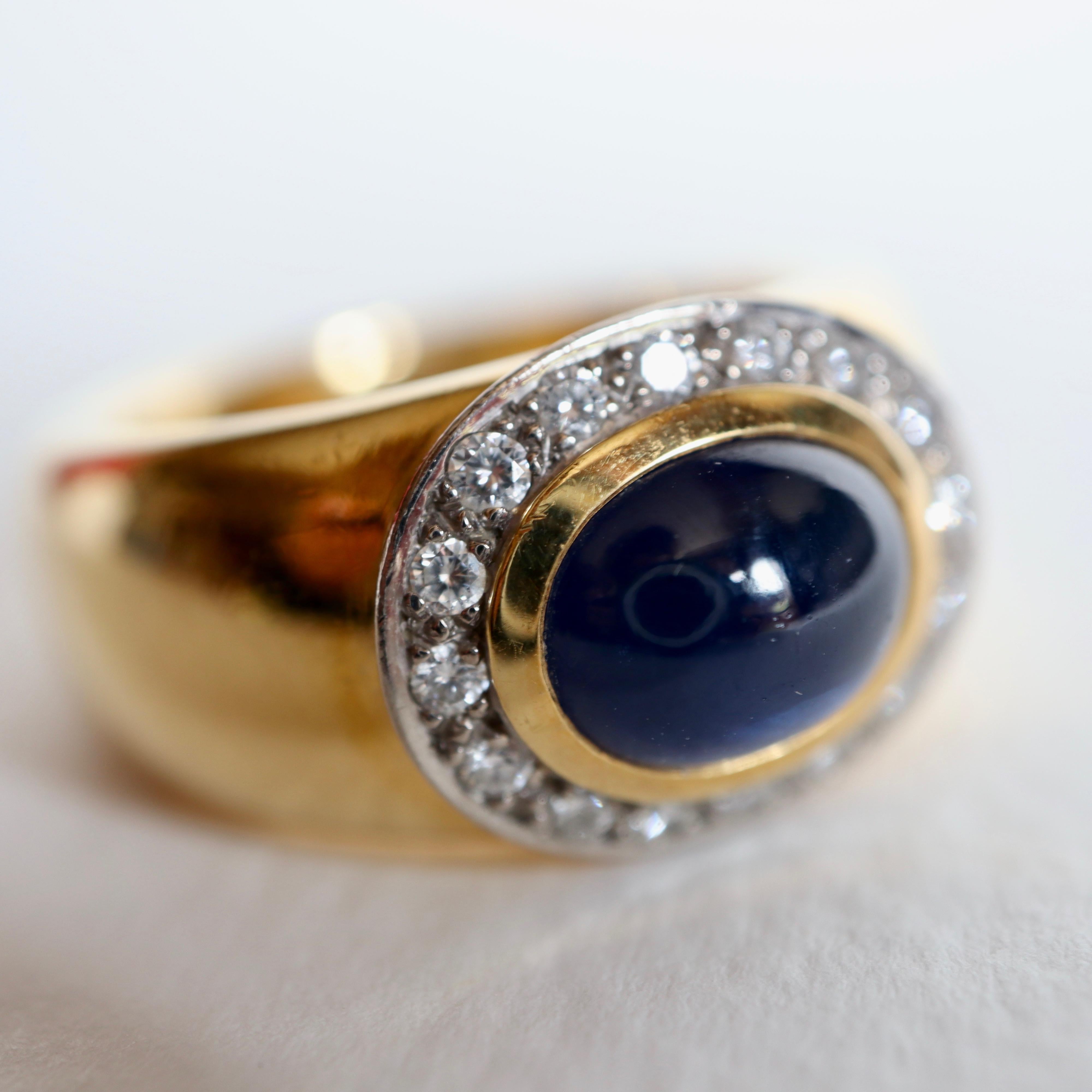 WEMPE Ring in Yellow and White 18 Carat Gold setting a Sapphire Cabochon with entourage of 16 Diamonds of 0.02 Carat each for a total of 0.3 Carat.
Signed Wempé and Numbered 4690 
Traces of Wear on the underside of the Ring
Dimensions of Sapphire 9