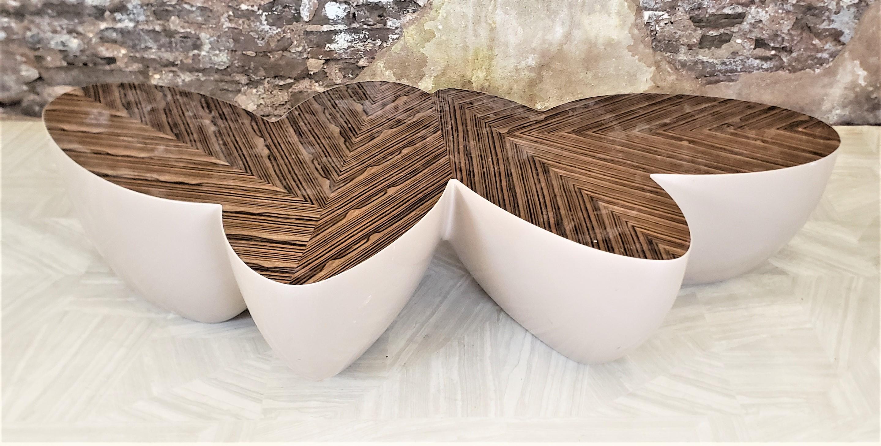 This coffee table was designed by Wendell Castle of the United States in approximately 1990 in his signature Modern Organic style. This coffee table is known as his Sizzle table and has a biomorphic shape with four palm leaf shaped 'pods'. The table