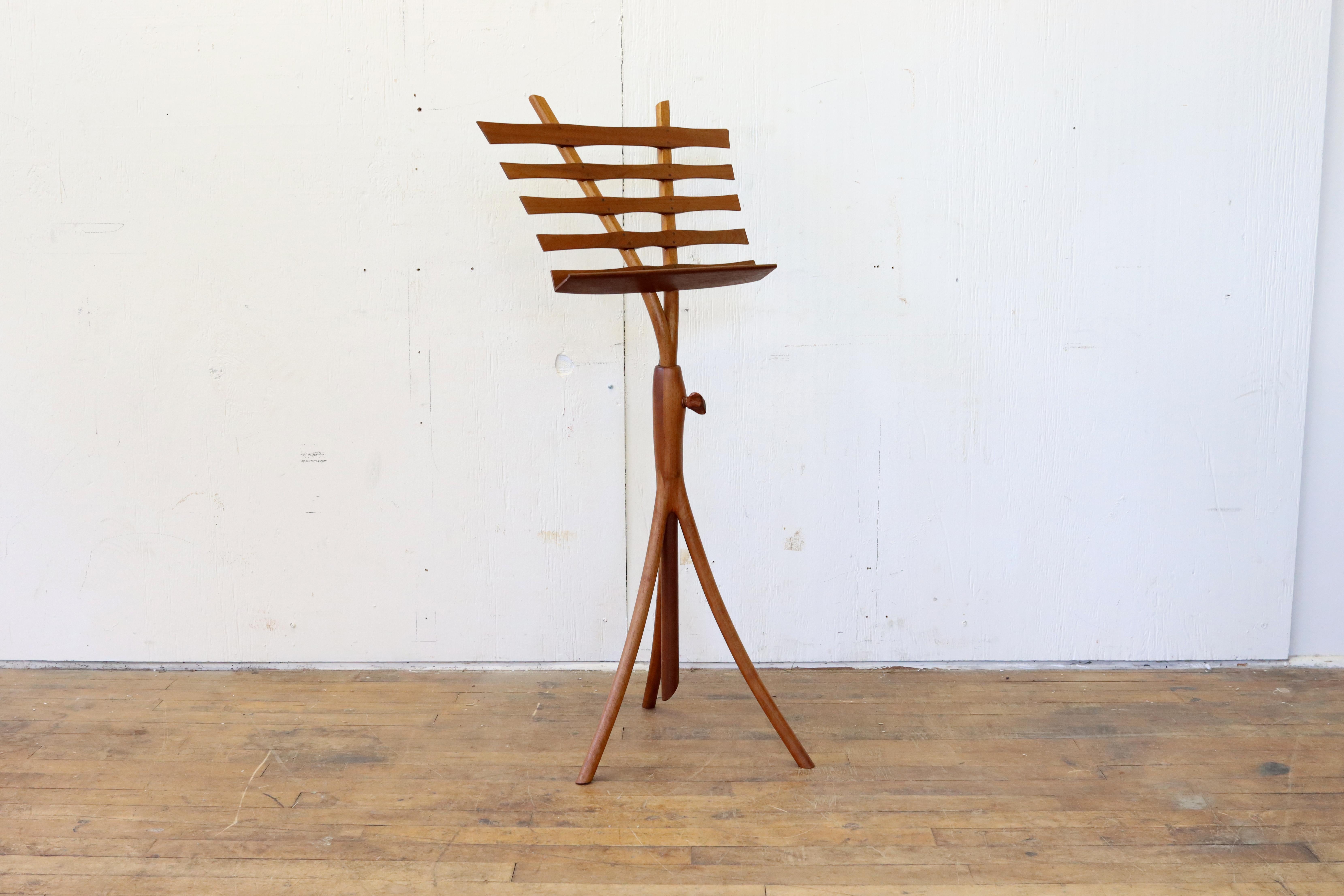 A stunning vintage studio woodworker music stand in the style of Wendell Castle or Wharton Esherick. This beautiful hand-crafted modernist stand has a curved tripod base supporting an adjustable height rack. The rack is constructed of a two-pronged