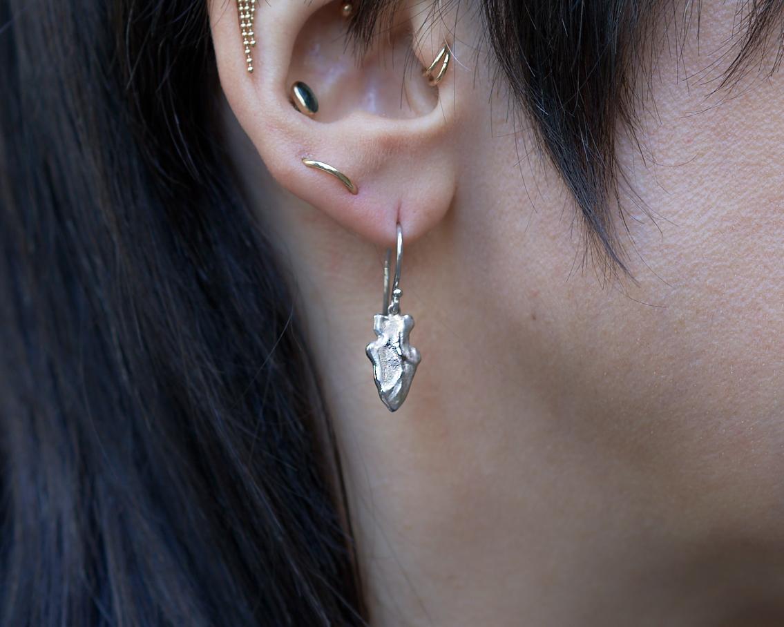 The arrowheads were cast directly from an arrowhead that Wendy found in the backyard of her childhood home in the 1970s. The asymmetry is intentional, to reflect the original rough-hewn artifact.

Platinum, satin finish.
Arrowhead alone is 15