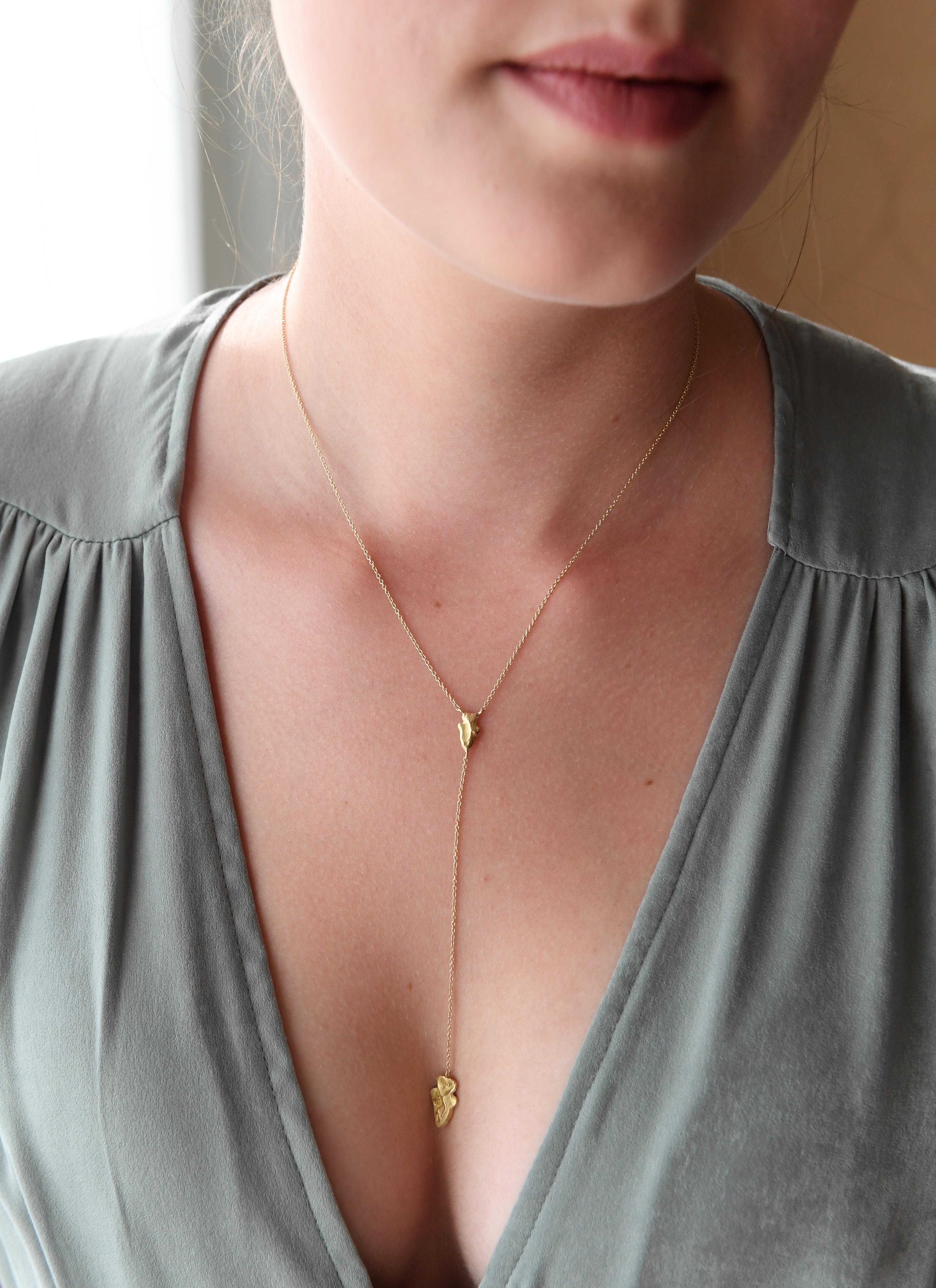 18K yellow gold, satin finish.
Smaller arrowhead is 10 millimeters long; 5 millimeters wide.
Larger arrowhead is 15 millimeters long; 9 millimeters wide.
Chain around neck is approximately 15 3/4
