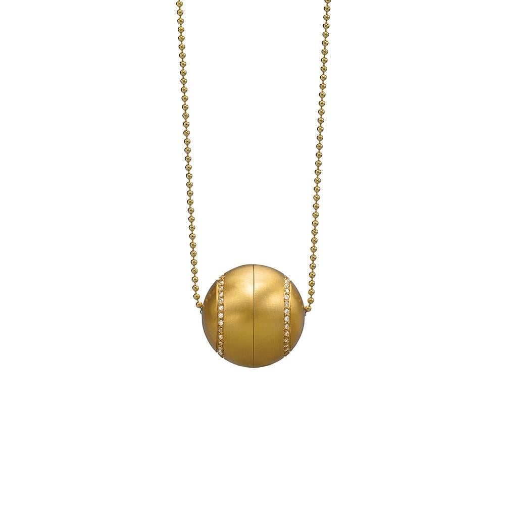 Locket unscrews.
18K yellow gold, satin finish.
35 points of white diamonds.
28