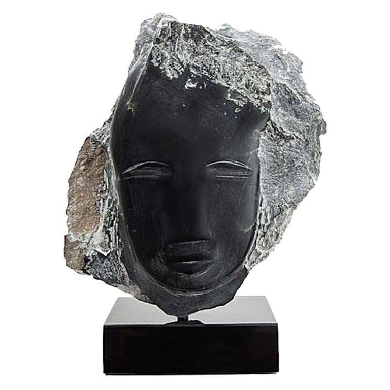 Sculpture de tête en albâtre noir de la sculptrice américaine contemporaine Wendy Hendelman sur une base en marbre noir. Le travail d'Hendelman reflète son amour du primitif et de l'ancien. La petite échelle et le style ont établi son identité en