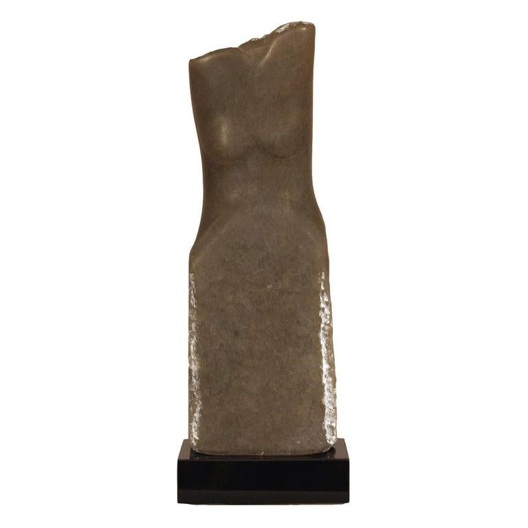 Contemporary American sculptor Wendy Hendelman's gray alabaster torso sculpture on a rotating black marble base. Hendelman’s work reflects her love of the primitive and the ancient. The small scale and style have established her identity as a