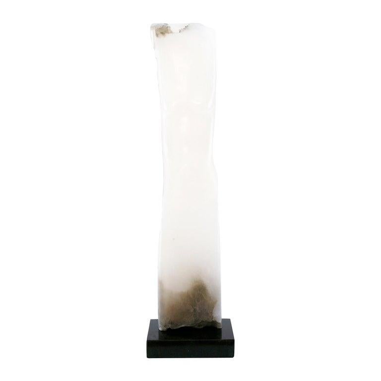 Contemporary American sculptor Wendy Hendelman's tall white Alabaster Torso sculpture on a black marble base. Hendelman’s work reflects her love of the primitive and the ancient. The small scale and style have established her identity as a sculptor
