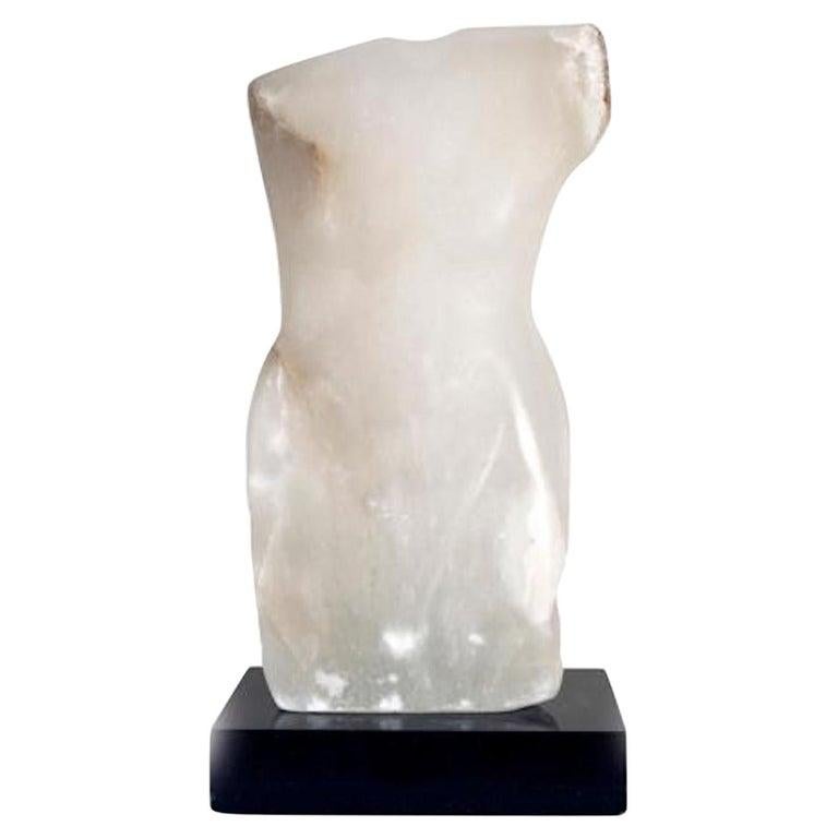 Contemporary American sculptor Wendy Hendelman's White Alabaster Torso Sculpture on a black marble base. Hendelman’s work reflects her love of the primitive and the ancient. The small scale and style have established her identity as a sculptor as