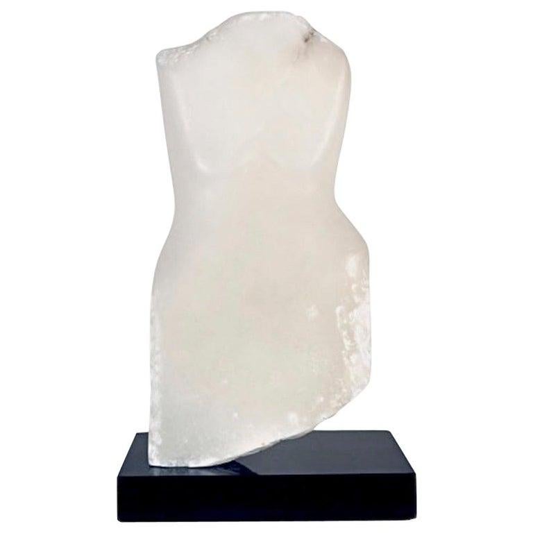 Contemporary American sculptor Wendy Hendelman's White Alabaster Torso Sculpture on a black marble base. Hendelman’s work reflects her love of the primitive and the ancient. The small scale and style have established her identity as a sculptor as
