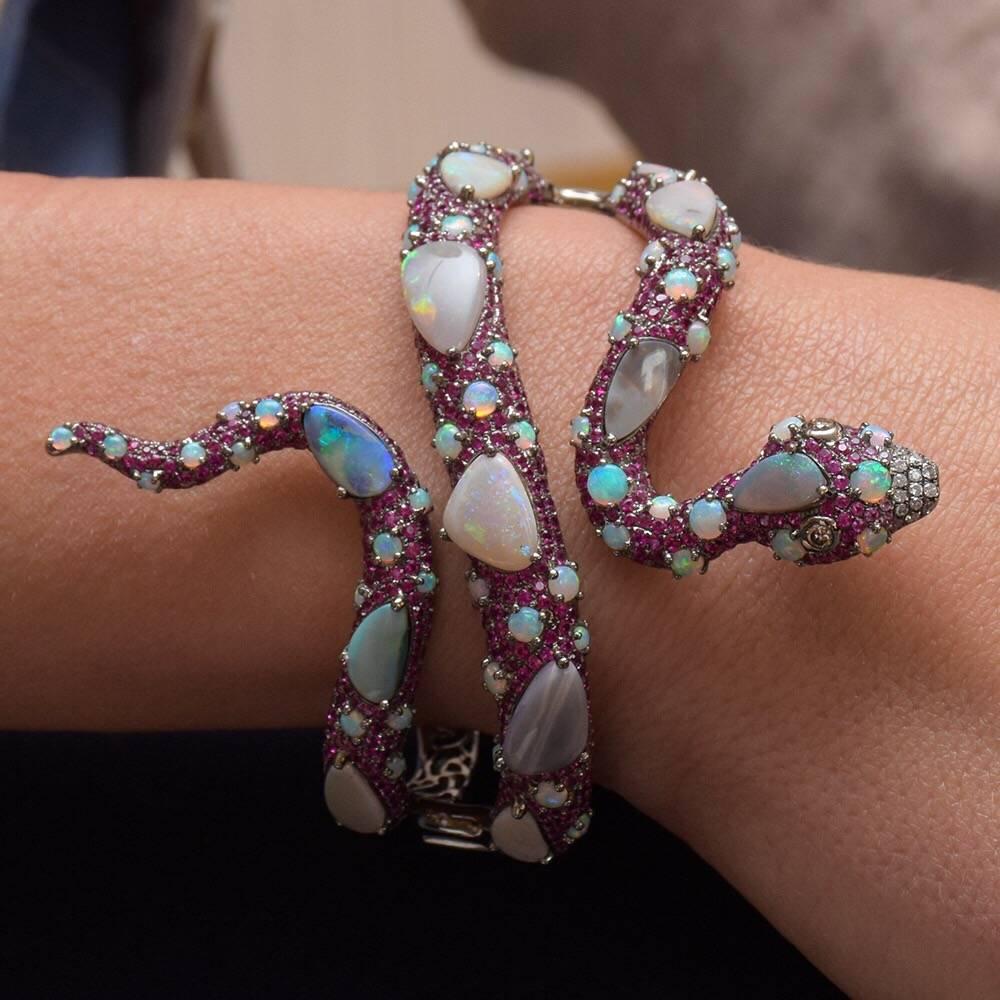 With a fascination of exotic landscapes and wildlife, Wendy Yue's jewelry radiates opulence and whimsical characteristics with a wide range of color and details. This one-of-a-kind Wendy Yue pavé ruby serpent cuff is accented with white opals and