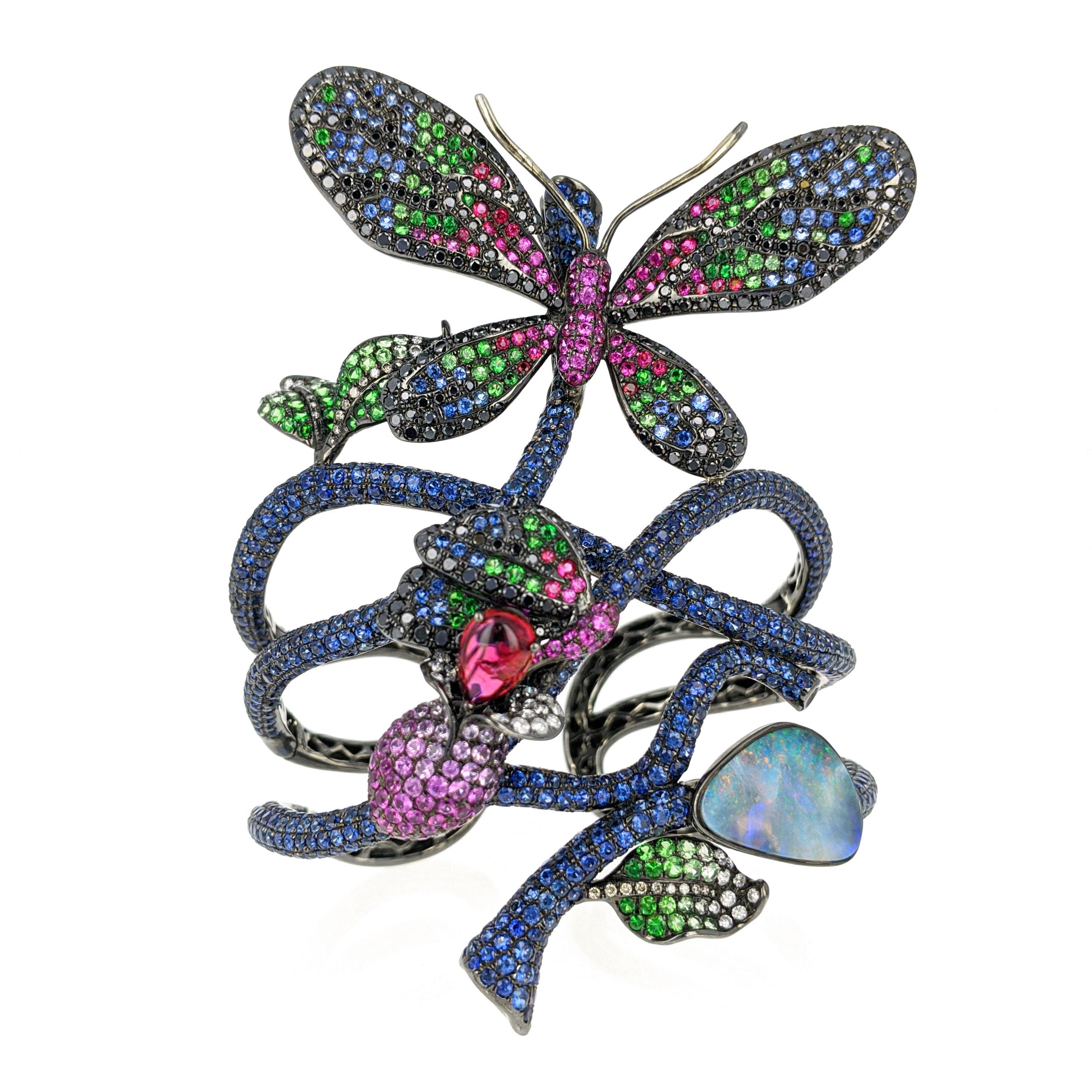 This whimsical and vibrant 'Madame Butterfly' cuff bracelet by Wendy Yue features a butterfly motif consisting of blue and pink sapphires, rubies, colorless and black diamonds, tsavorites, tourmaline and opal mounted in 18 karat blackened gold. The