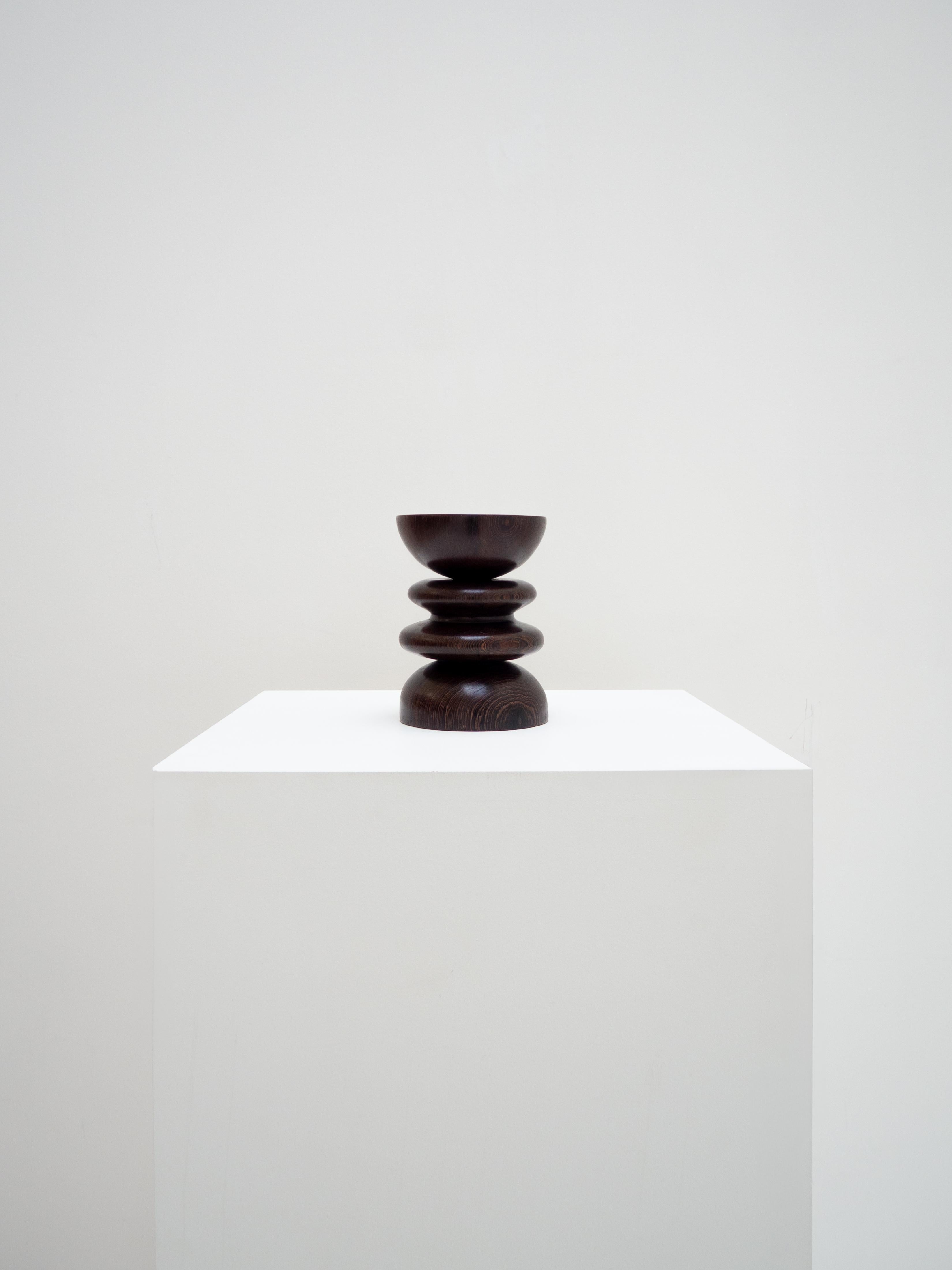 This bowl was designed by woodcarver Romie Objetti. Turned from locally sourced wenge wood, it stands out with its pronounced curves and height, giving it a strong sculptural presence.