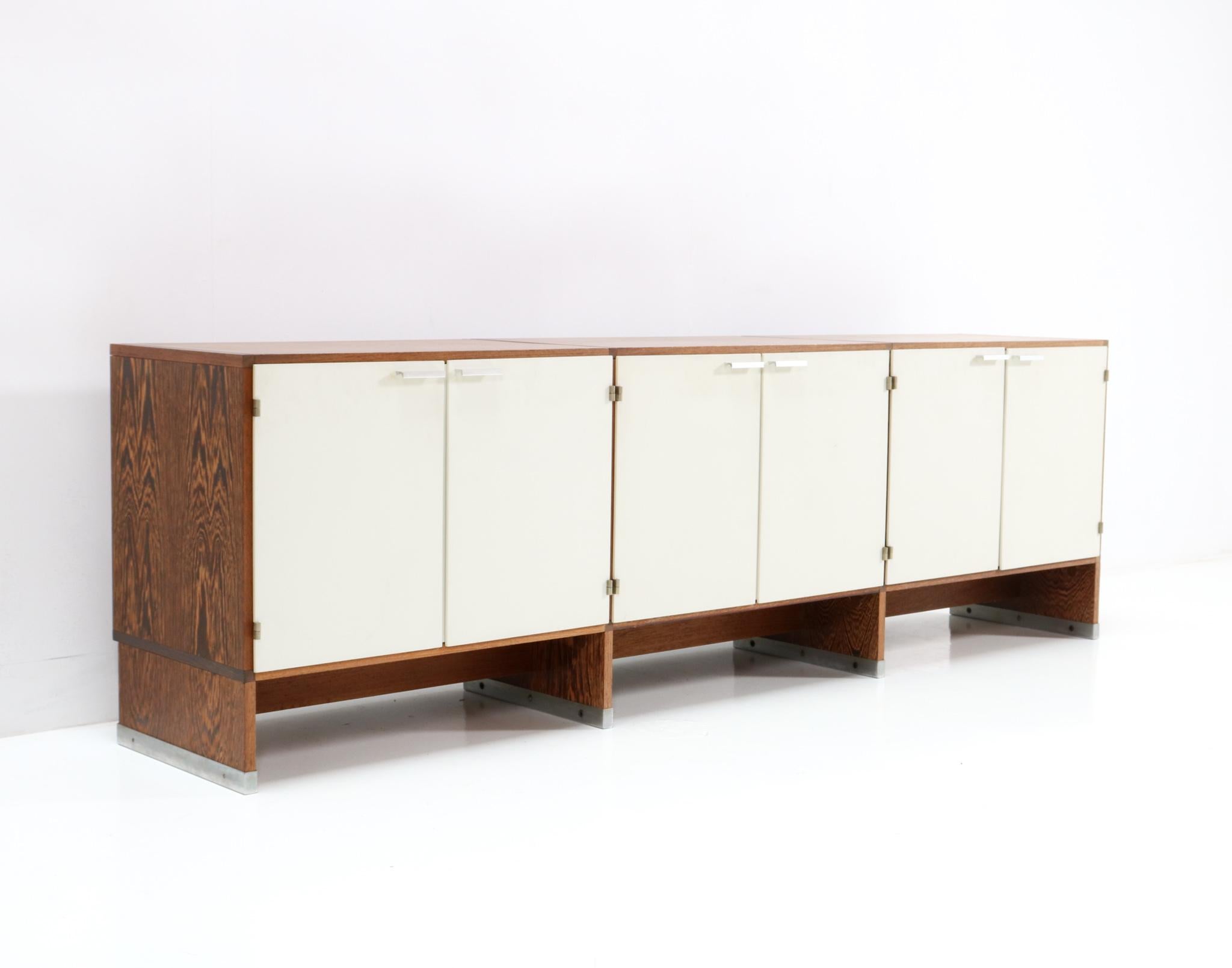 Magnificent and rare Mid-Century Modern credenza or sideboard.
Design by Cees Braakman for Pastoe.
Striking Dutch design from the 1960s.
Original wenge veneered pressed wood base with original white laminated doors.
Marked Pastoe inside.
This