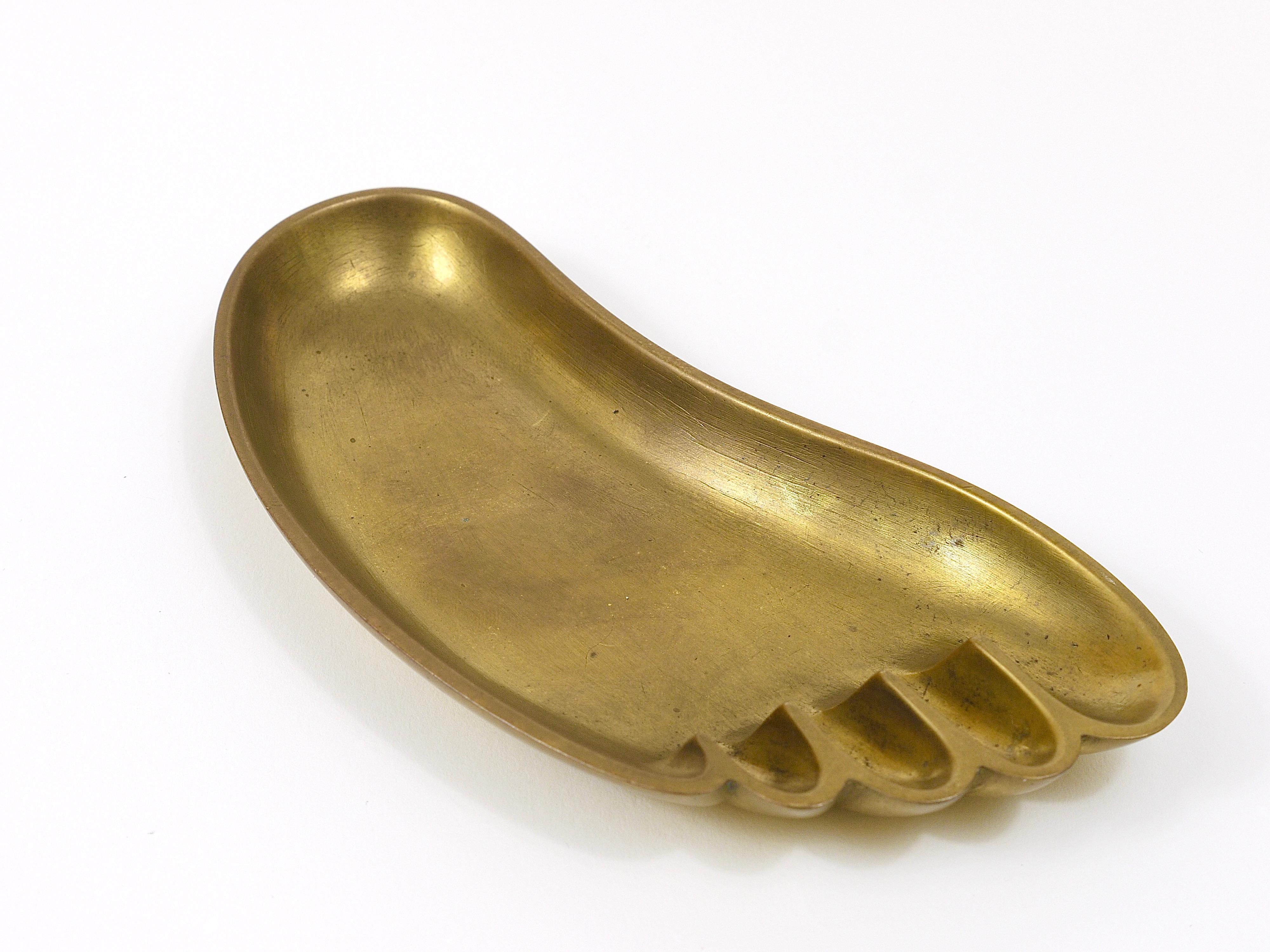 A charming and humorous Austrian brass bowl or tray in the shape of a foot, designed and executed by Werkstatte Hagenauer Vienna in the 1950s. also suitable as a jewelry bowl or „vide-poche“. Good condition, nice patina, marked on its bottom: Whw