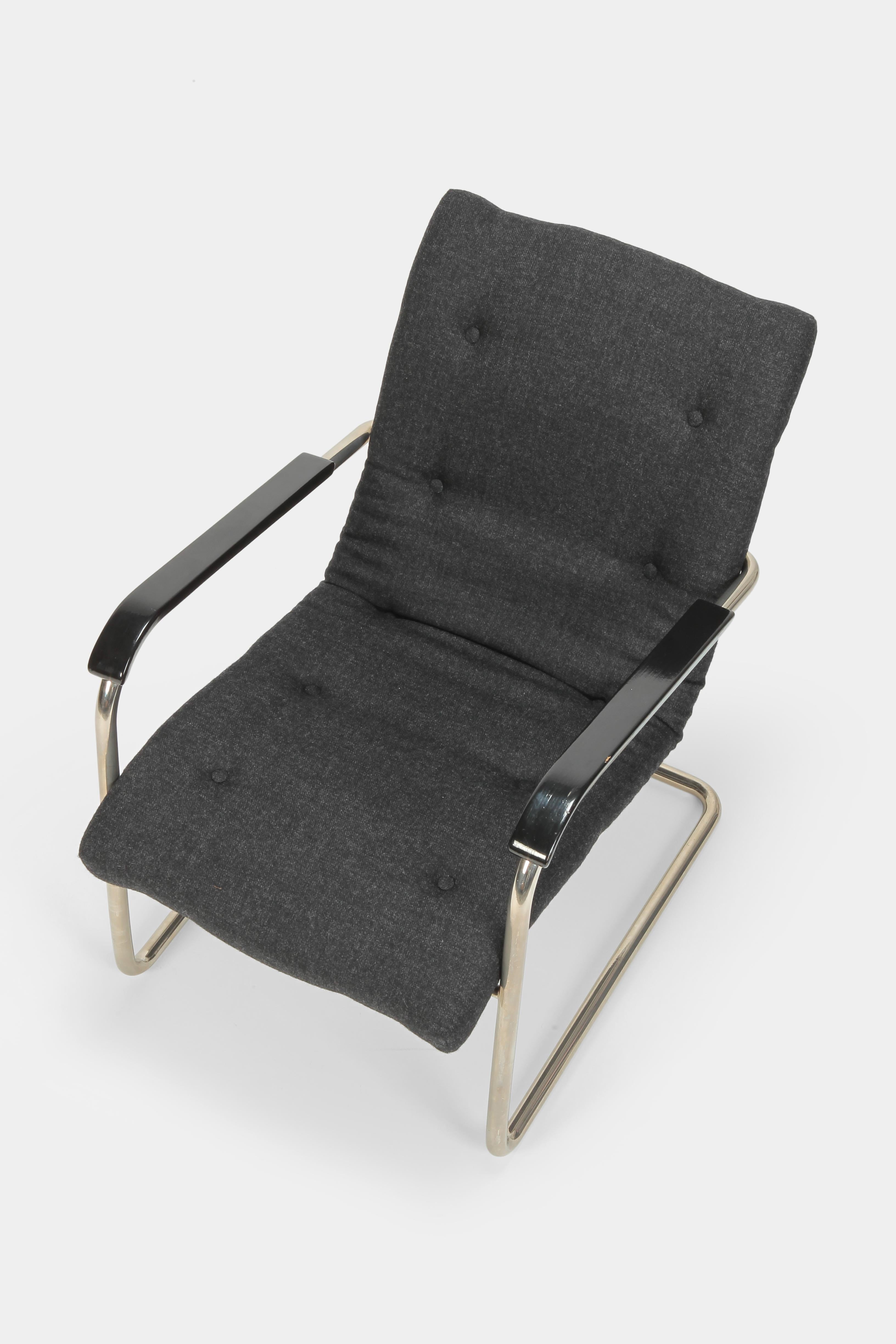 Design 1930 by Werner Max Moser for Embru/Wohnbedarf. Black painted armrests made of beech wood and nickel plated tubular steel. The seat cushion is freshly upholstered with the corresponding buttons and covered with grey woolen fabric from the