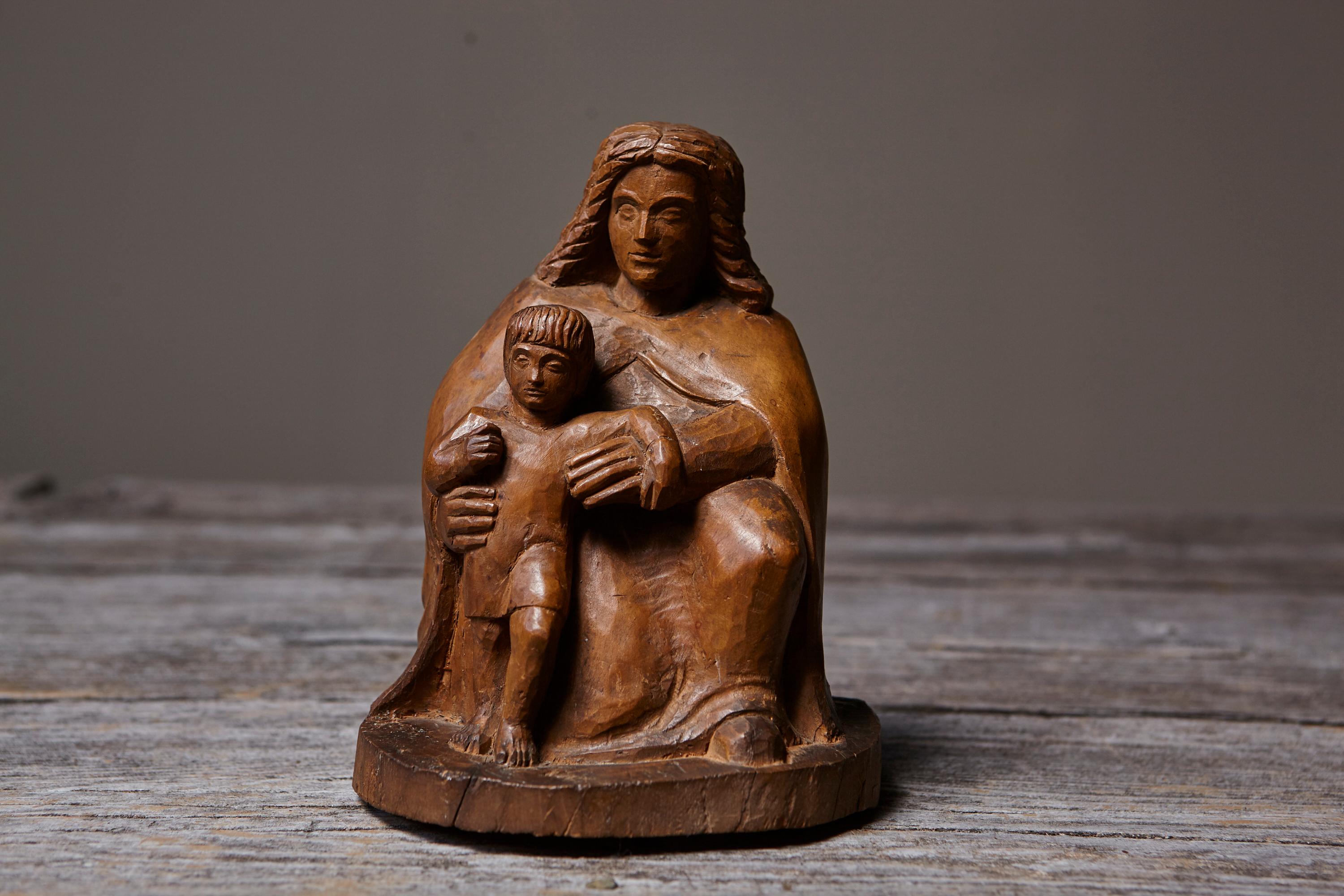 Sculpture unique en bois sculpté de l'artiste allemand Werner Meurer (1911-1986), représentant une mère assise tenant son enfant dans un geste de protection tranquille. Contrairement aux bronzes de Meurer, qui étaient généralement coulés en séries