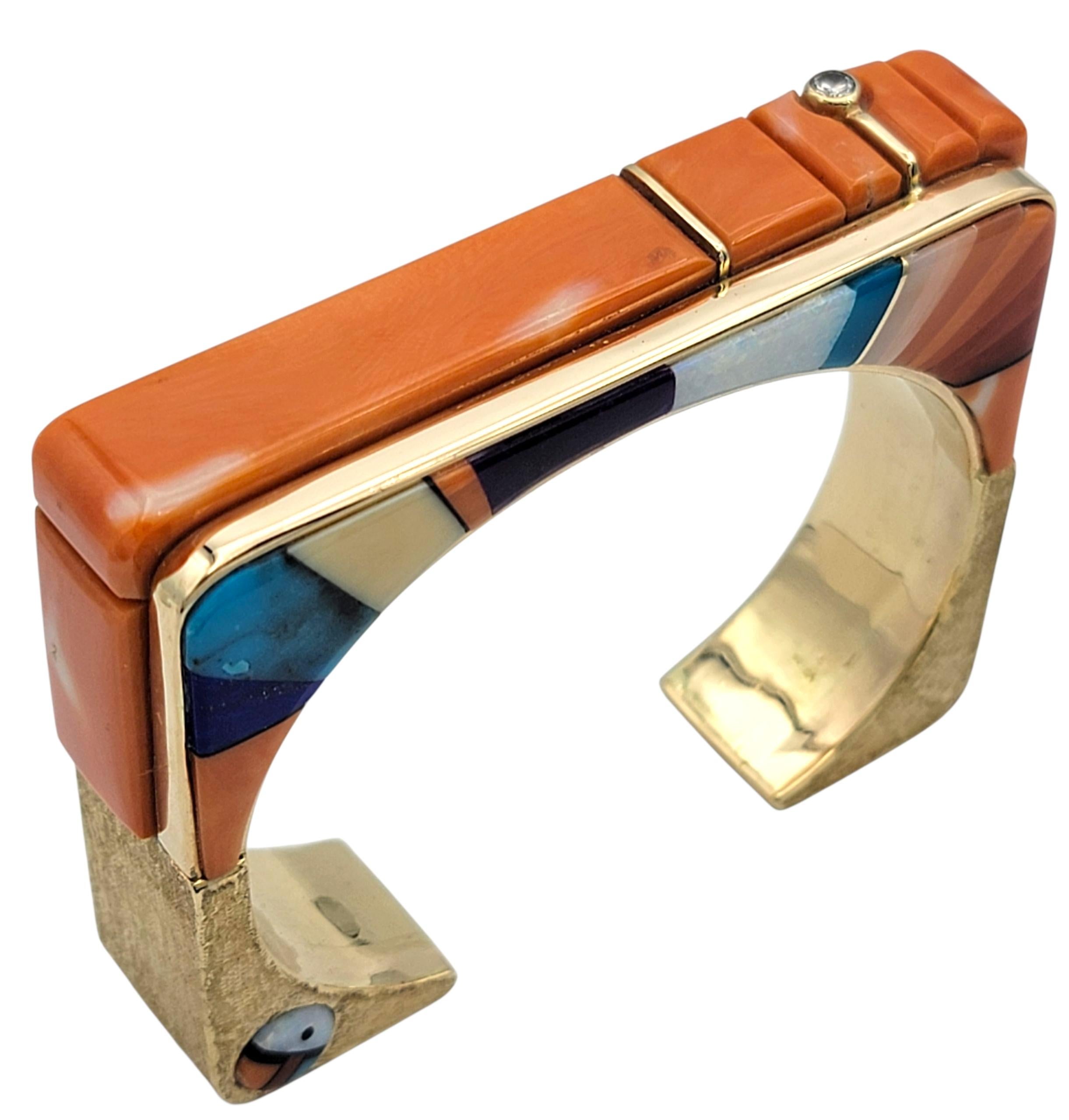 This striking squared cuff bracelet by renowned Navajo artist, Wes Willie, showcases his signature artistry and precision. Crafted in 14 karat yellow gold, the bracelet features a masterful inlay of vivid coral, turquoise, white opal, sugilite, and