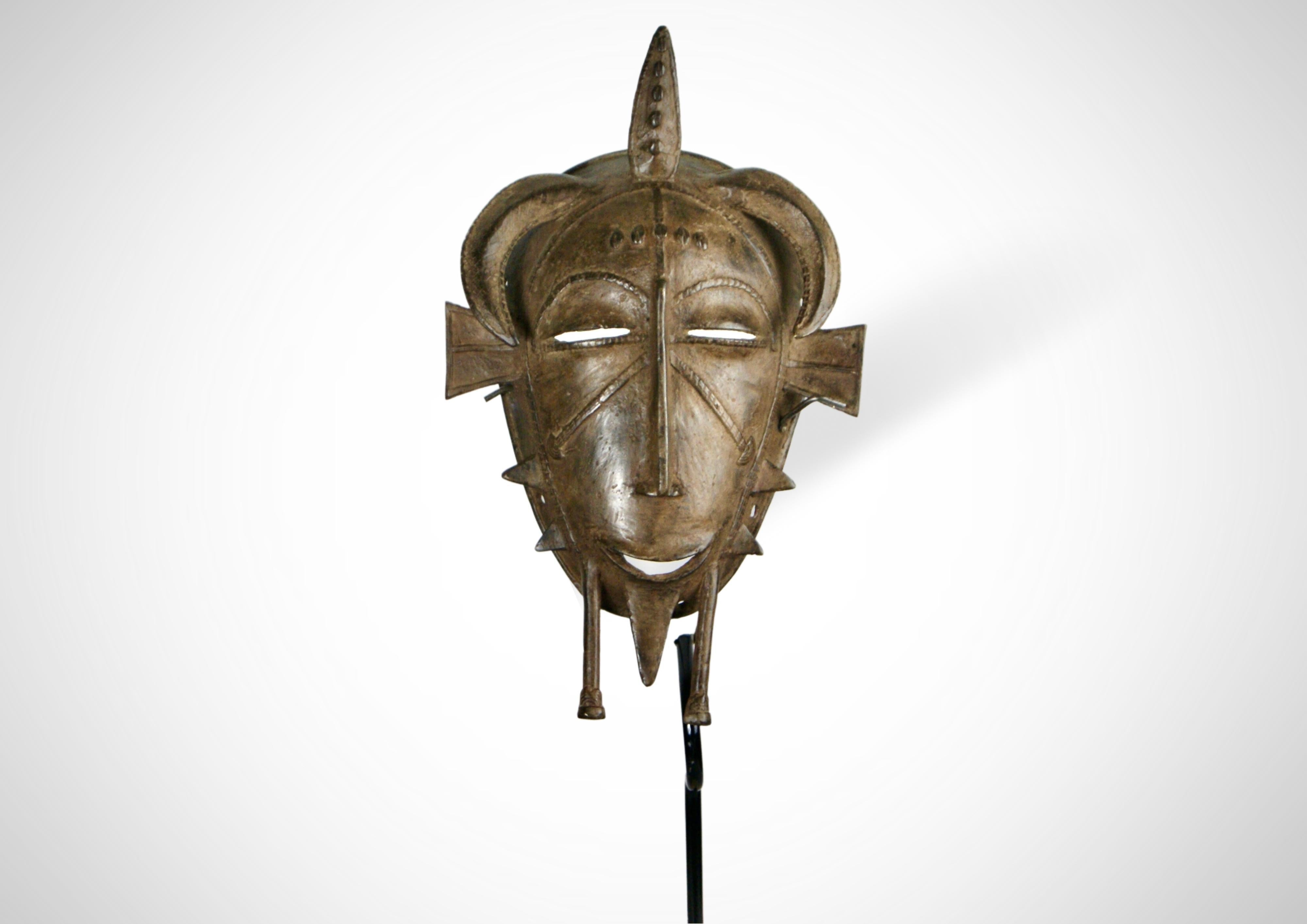 Gesichtsmaske der Senufo aus Bronzeguss (Kpelie) von der Elfenbeinküste in Westafrika.
Hergestellt nach dem Wachsausschmelzverfahren.
Traditionell ist die 