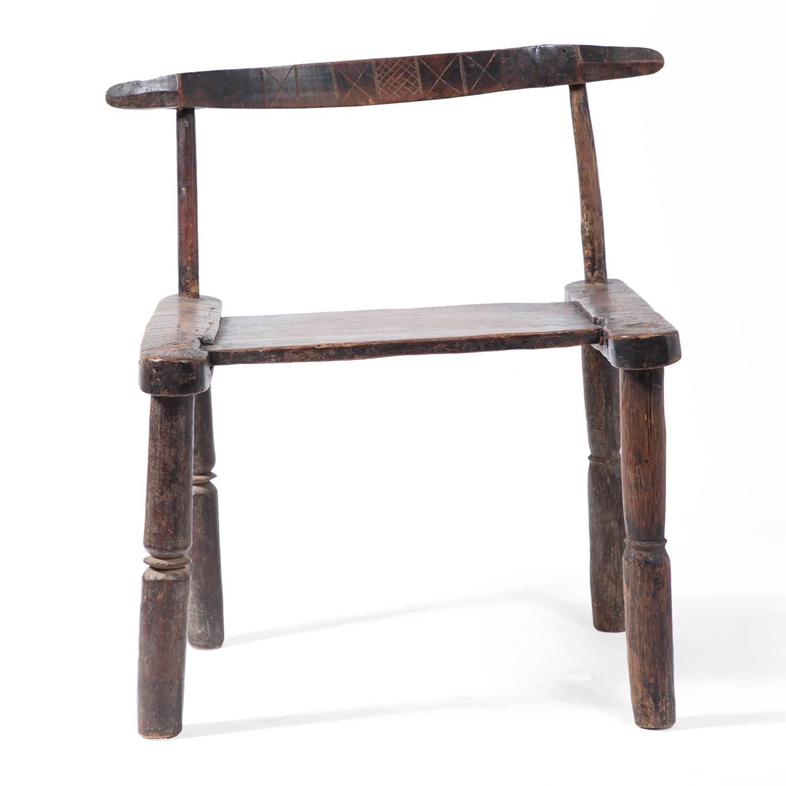 In West African tribes—such as the Dan, Senufo and Baule—chiefs and families have used low wooden chairs for centuries. A talented woodworker hand-carved the chair’s curved backrest, sculpted legs, flat seat and lateral struts. Incised marks on the