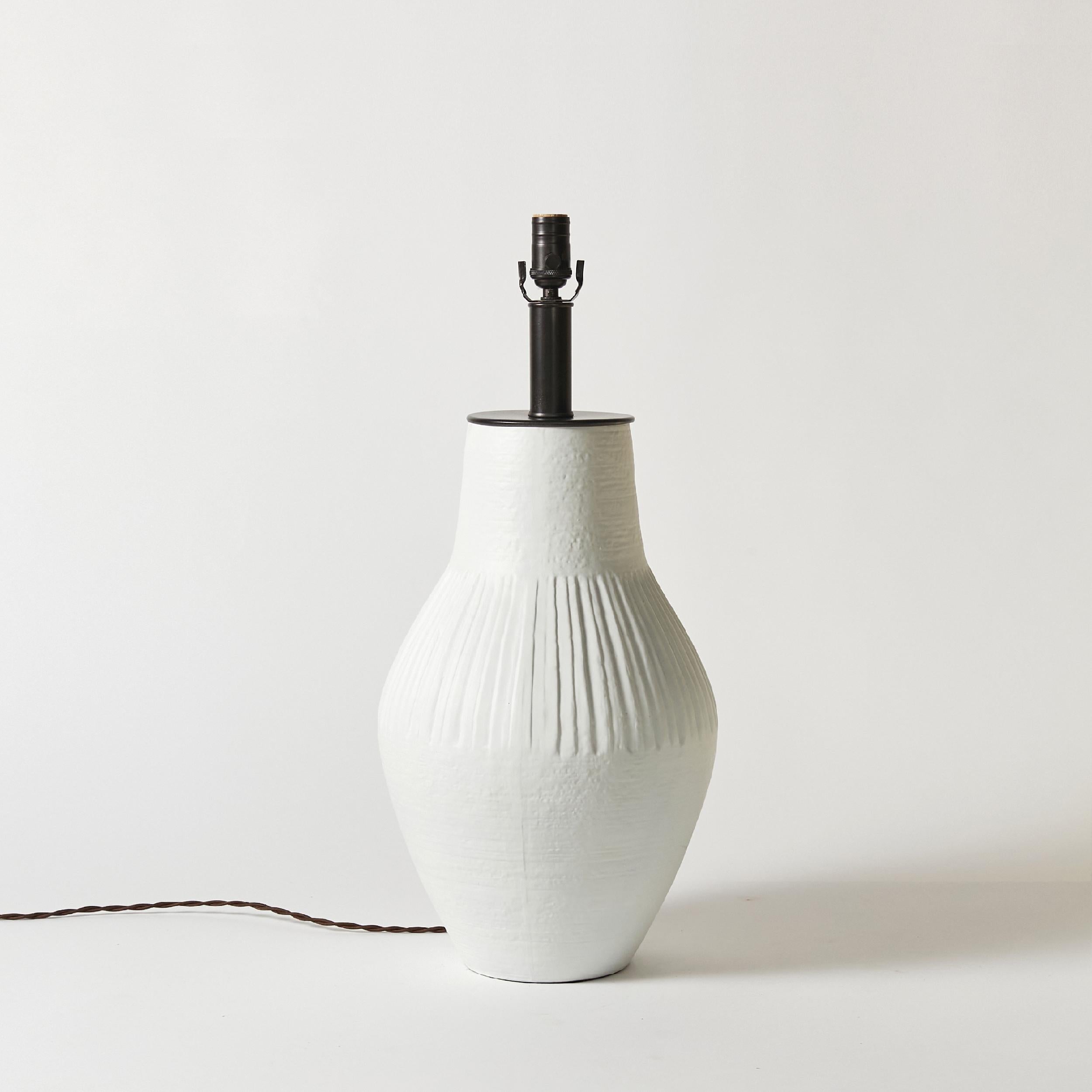 Midcentury west coast pottery table lamp finished in white gesso.
This item has been rewired with new hardware and braided cloth cord. This lamp does not include shade or harp.