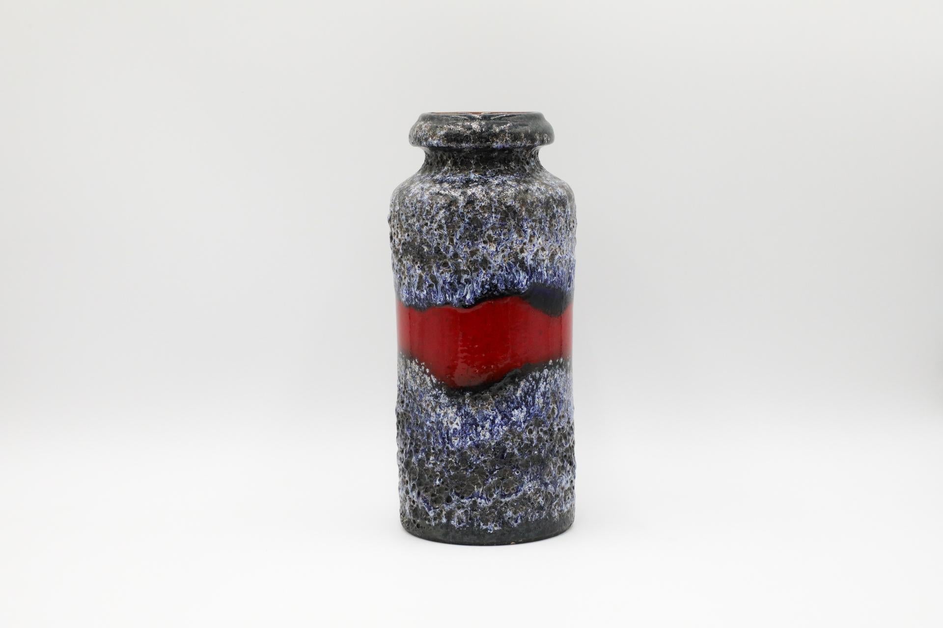 Grand vase ouest-allemand en céramique émaillée bleue et grise avec bande rouge. En état original avec une usure visible correspondant à son âge et à son utilisation.