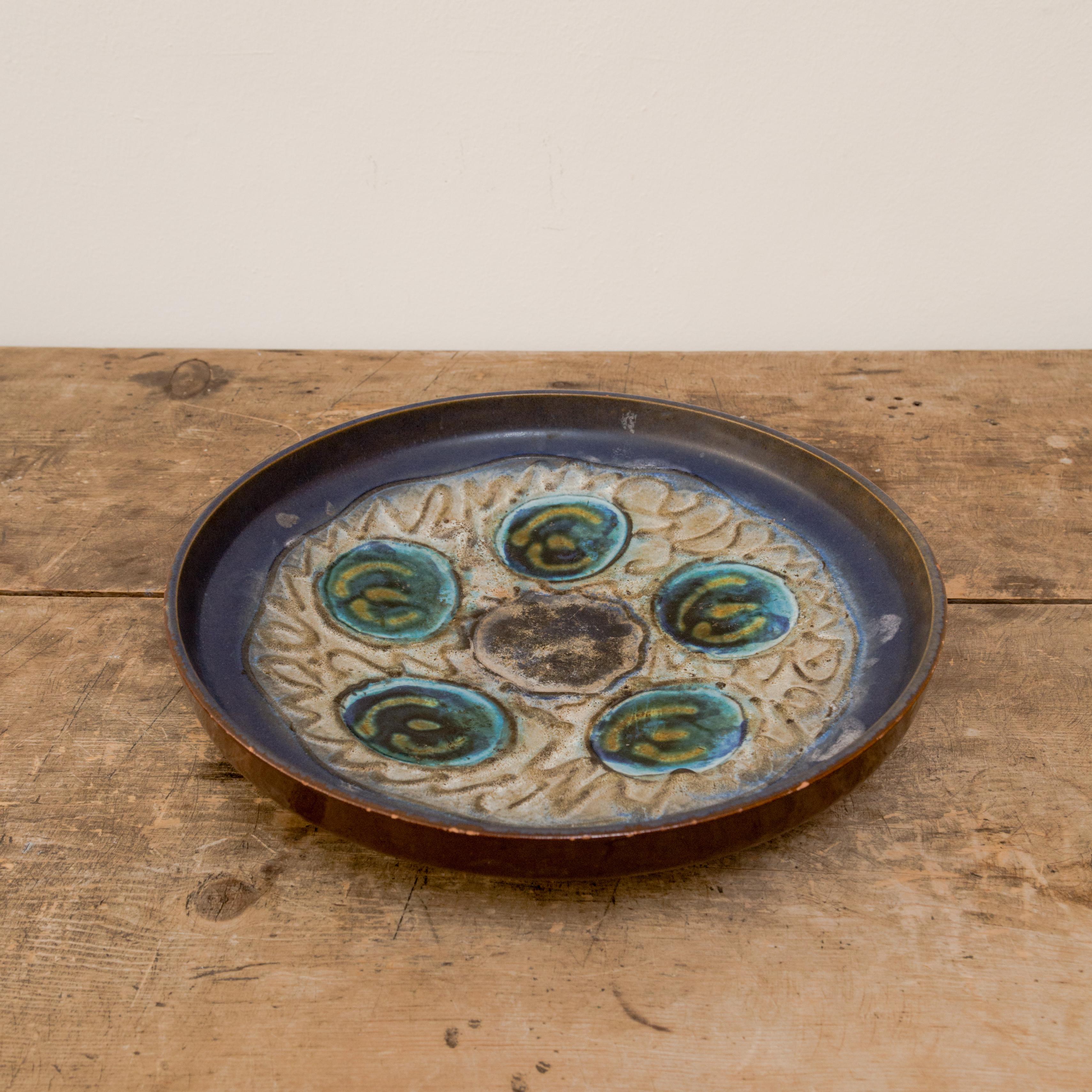 Cold war era, West German earthenware platter with scofridio incised design and varying shades of blue and natural glaze, Germany circa 1960's.