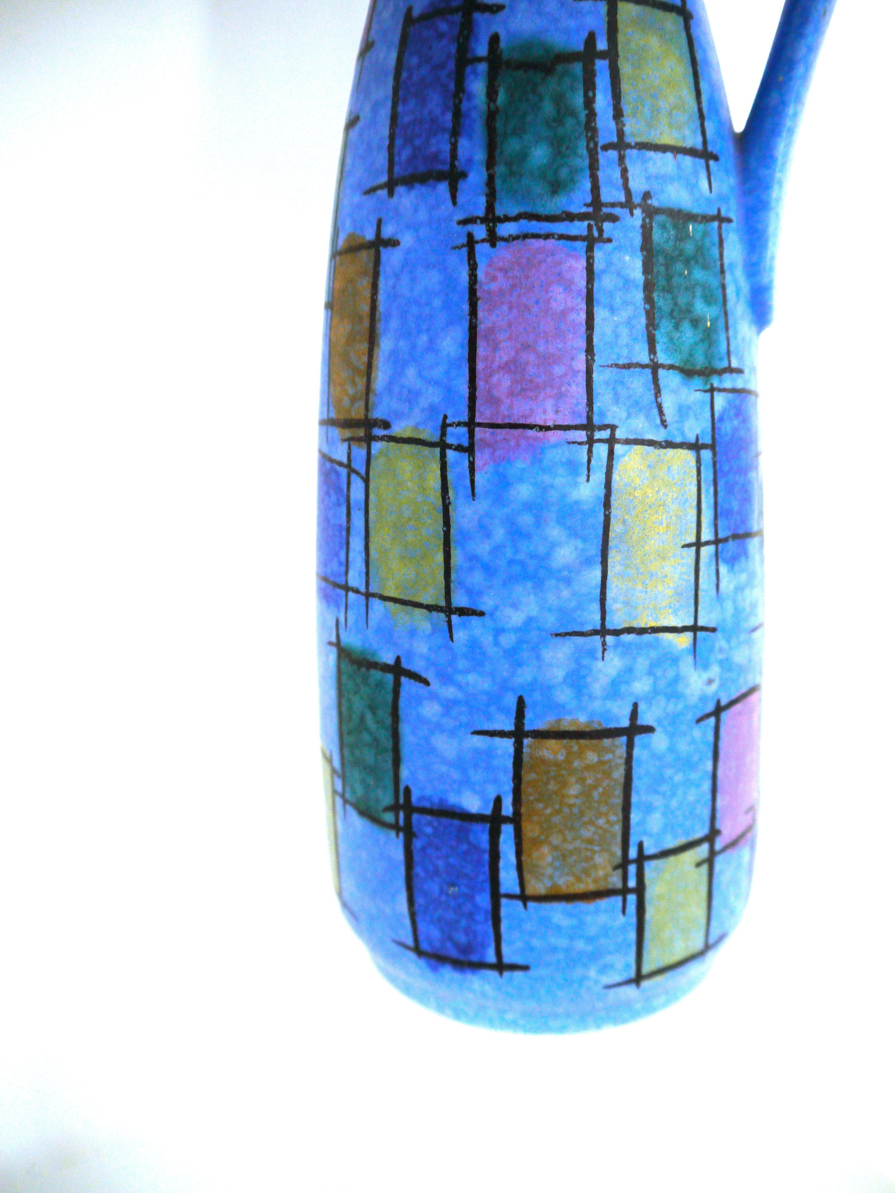 West German modernist ceramic pitcher Jasba Keramik 221/35
Impactful lapis blue color way with multi-color stencil design.

Height 35 cms
Width at widest point approximately 10 cms diameter 6 cms at mouth.

Jasba Keramik was formed in 1926 and