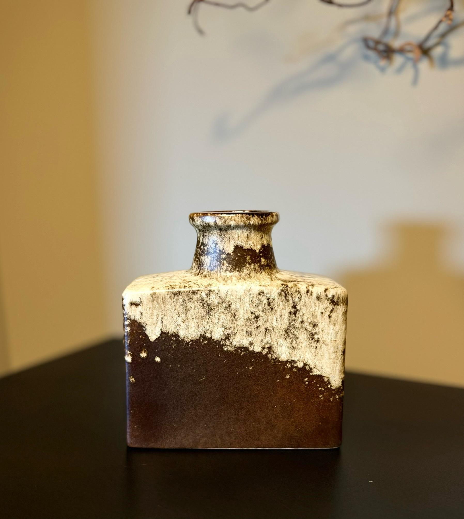 Description:
Offering a beautiful vintage Scheurich vase from the 1970s. This stunning piece showcases the iconic West German pottery style with its bold colors and unique design. The vase features a captivating brown and cream finish, epitomizing