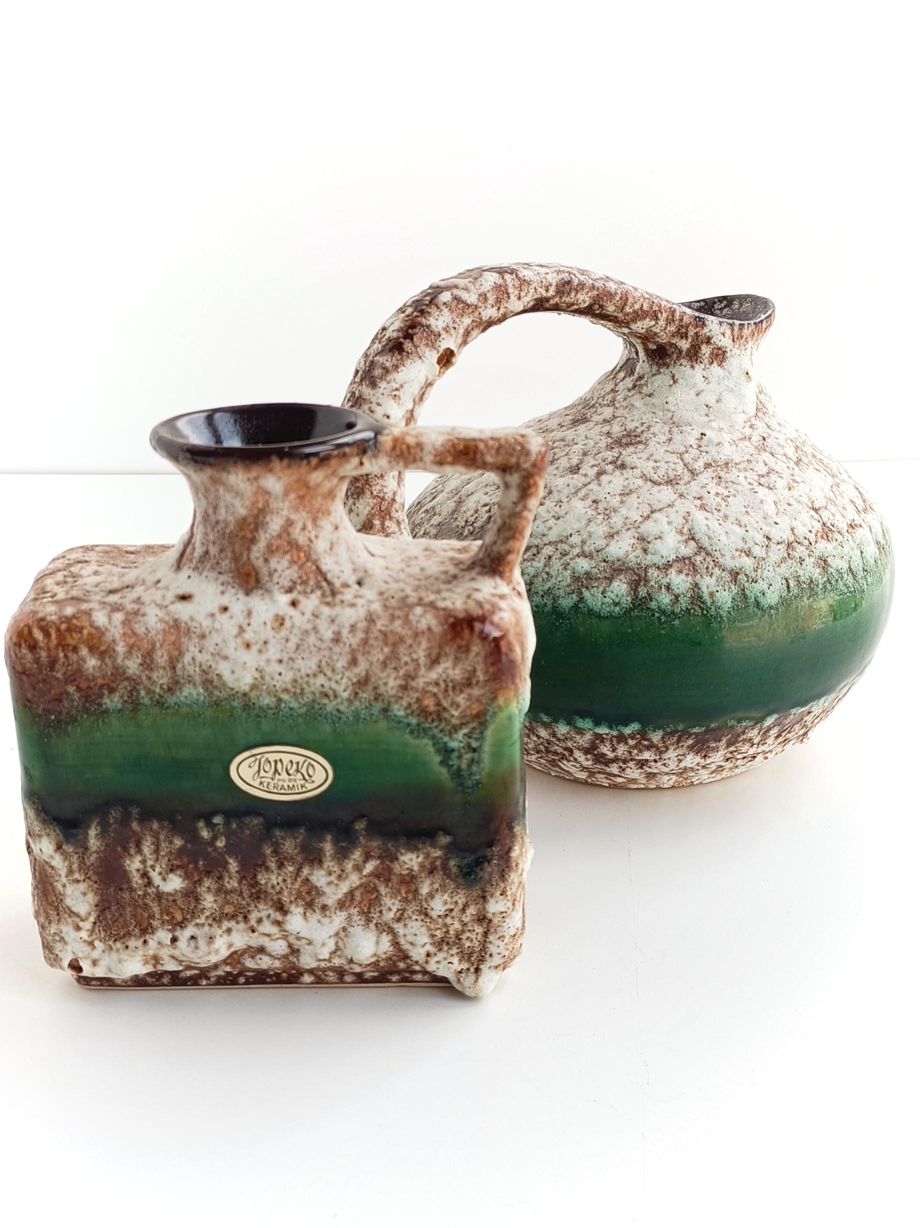 These Mid-century modern ceramic jugs by Prag Grün for Jopeko Keramik are highly sought after pieces among collectors of vintage ceramics. Hand-produced in West Germany circa the 1960s, these jugs represent a distinctive style characterized by bold,