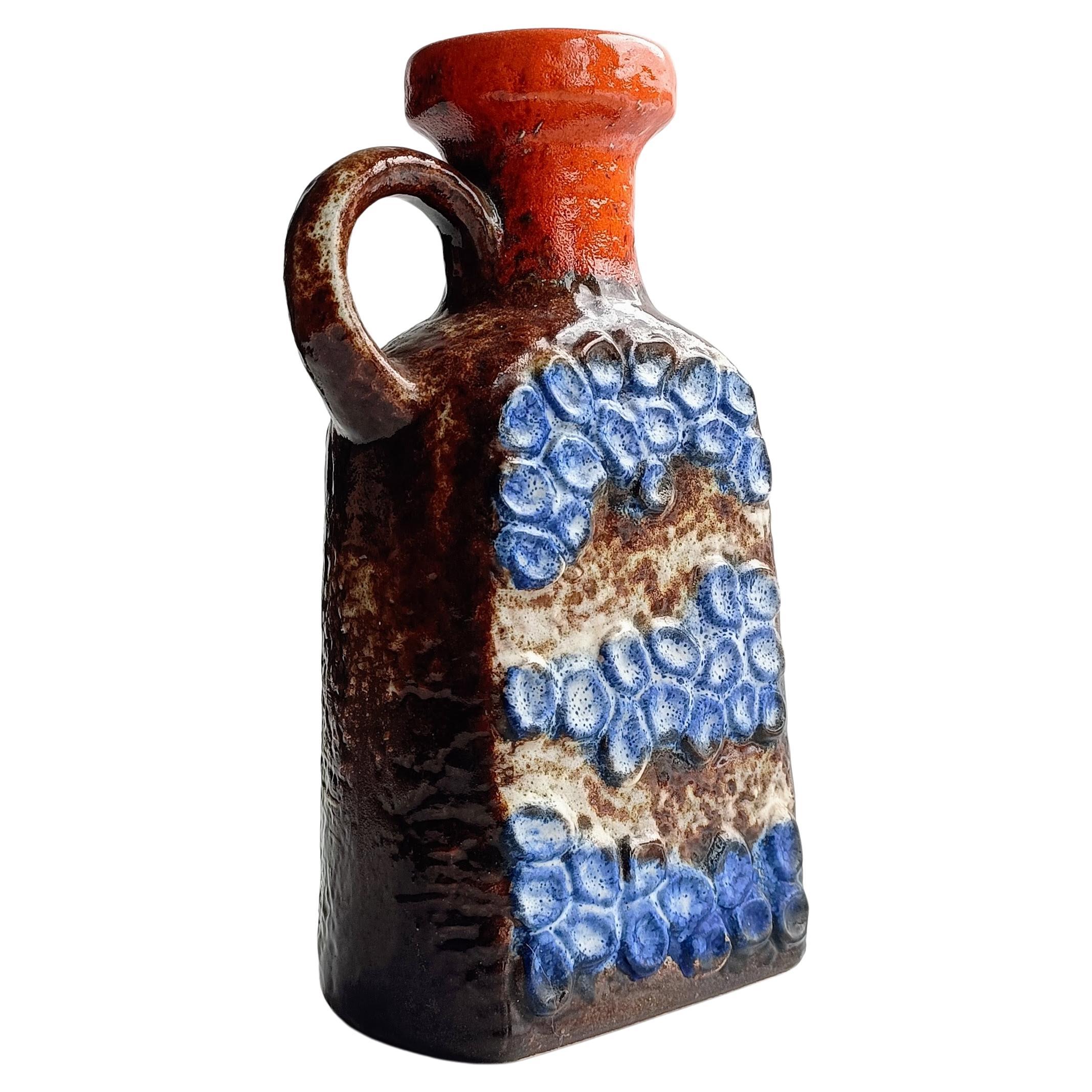 Une très belle cruche en céramique de l'Allemagne de l'Ouest en poterie d'art par Dümler & Breiden. Il présente le très recherché décor Domino dans les couleurs marron, orange et bleu.  Fabriqué à la main en Allemagne de l'Ouest vers les années