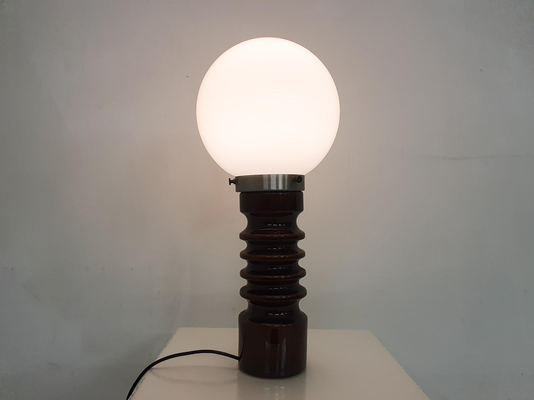 Brown ceramic lamp with a white glass globe. In good condition.