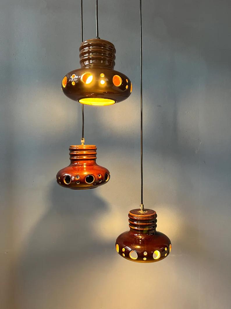 West germany cascade chandelier with three ceramic lights. The height of each individual light can easily be adjusted, the pictures show one possible example. The lamp requires three E27/26 (standard) lightbulbs.

Additional information:
Materials: