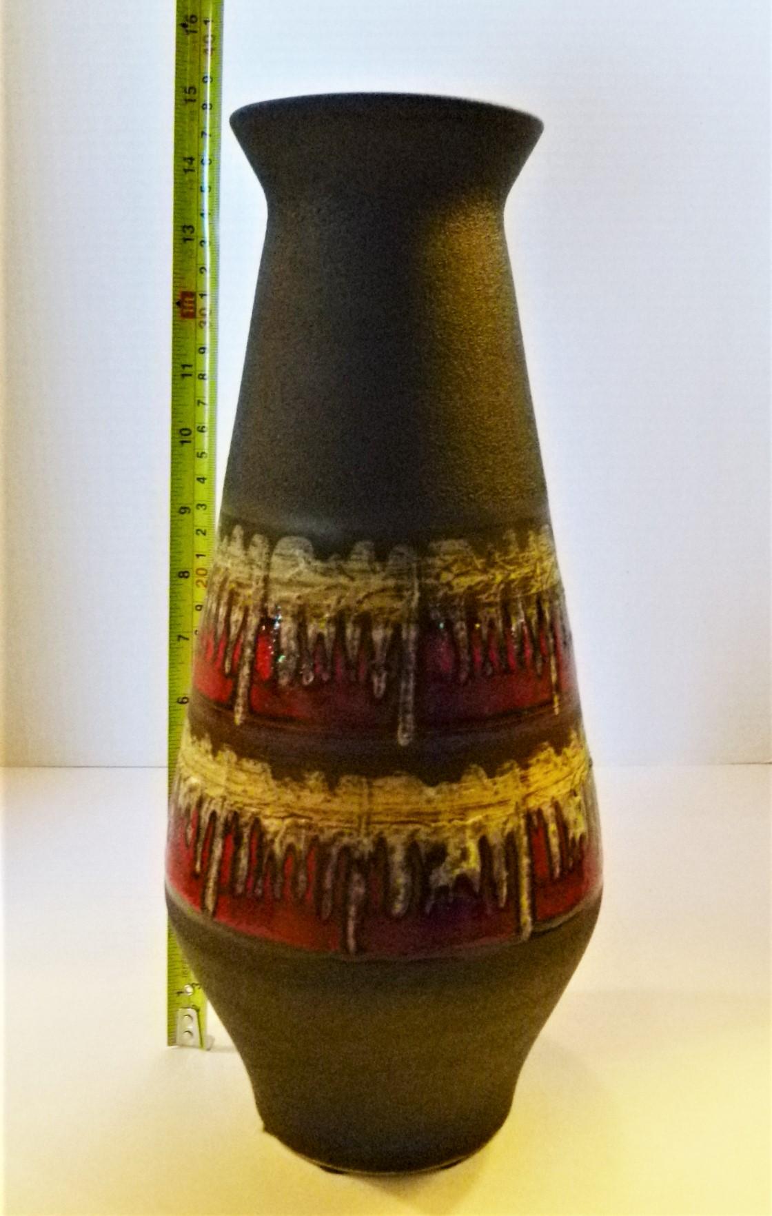 Wonderfully tall and elegant German vase by Jasba in 1959. With a black Fine pebble glaze accented by a drip lava glaze in reds, mustard and gray-green. Probably designed by Cilli Worsdorfer, the main designer at the time. It is marker on the bottom