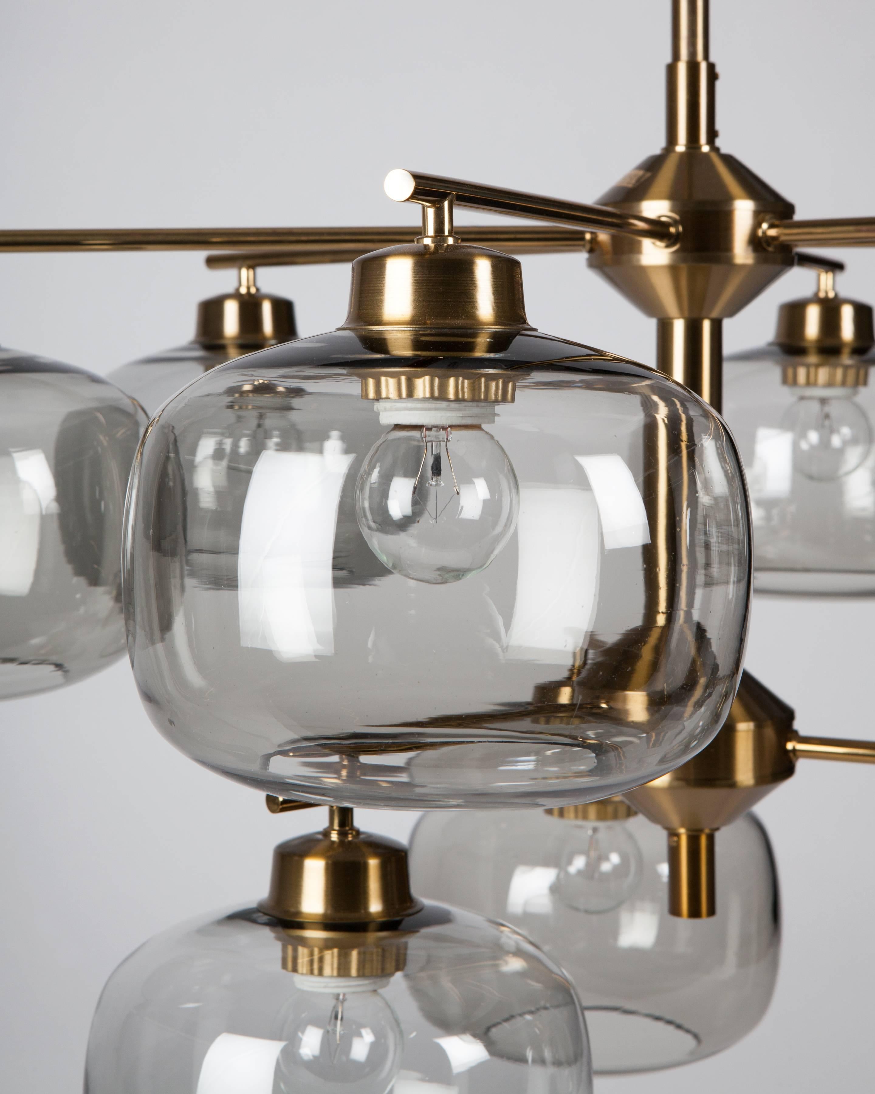 AHL4112
A vintage nine-light chandelier with smoked glass spherical shades in its original lacquered brass finish. Designed by Holger Johansson and signed by the Swedish maker Westal. Due to the antique nature of this fixture, there are some nicks