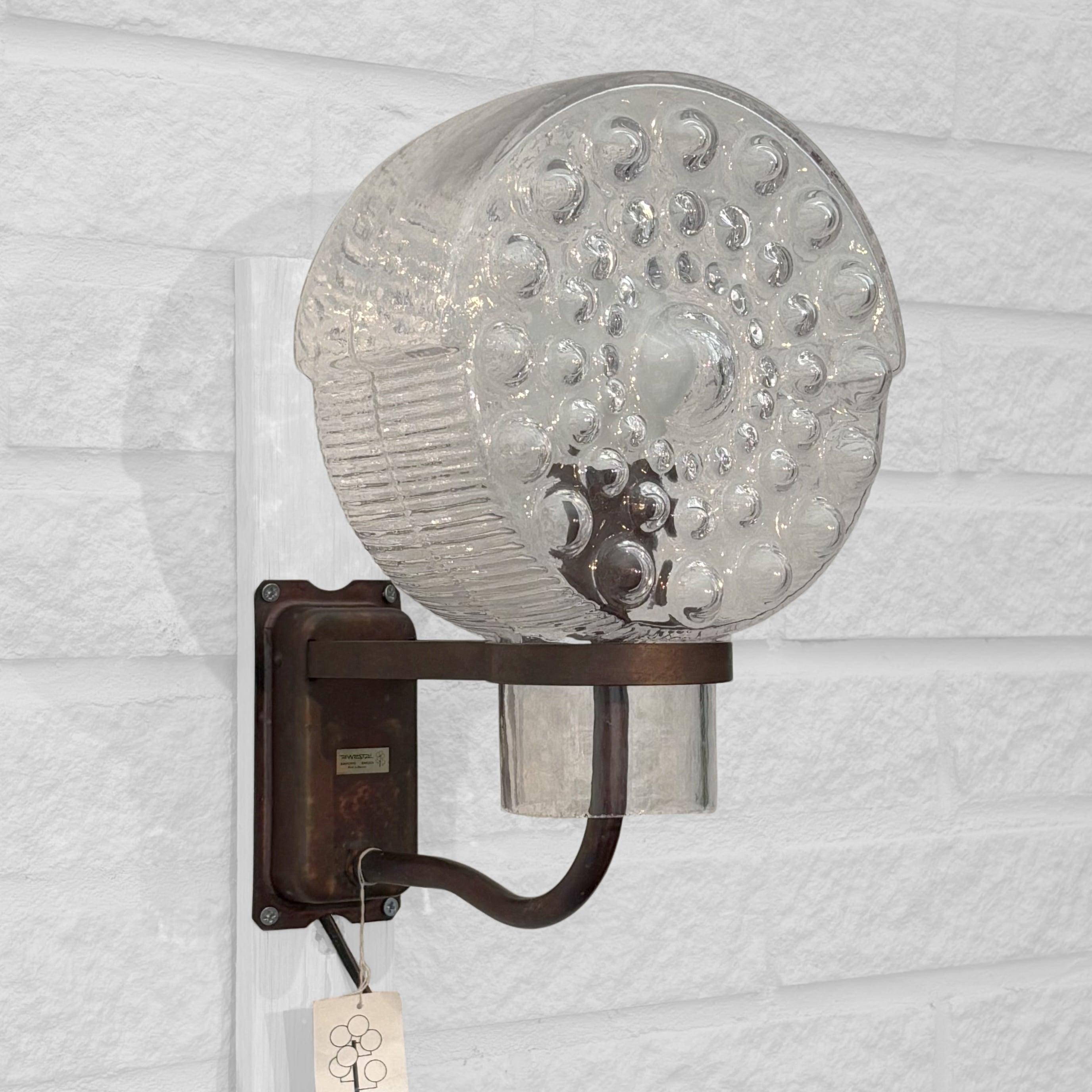 Un éclairage de façade extérieur sculptural produit par le fabricant suédois Westal dans les années 1960. Ce luminaire allie un design scandinave intemporel à des matériaux durables : une applique murale en cuivre patiné qui supporte un abat-jour en