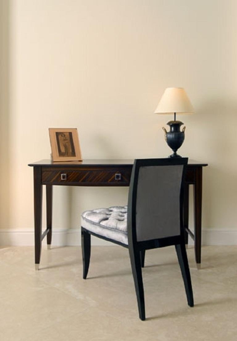 An elegant writing or dressing table finished in Macassar ebony.

Beautiful and versatile this table consists of three drawers with smart drop handles finished in polished nickel. The table stands on four elegant shaped legs fitted with polished