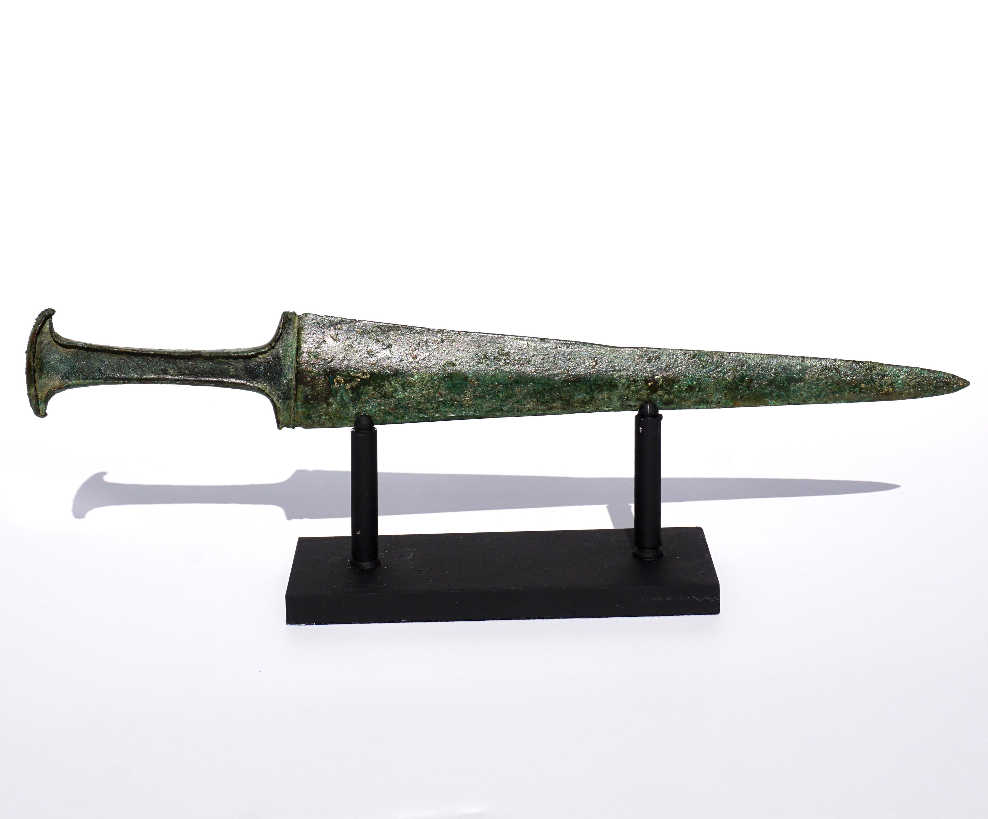 2000-700 BC. Luristan (Louiristan) Culture. Bronze dagger with a bevelled leaf-shaped blade and wrap-around handle culminating in an oval-shaped pommel. The handle would originally have been reinforced with a wooden insert. 

Bronze weaponry