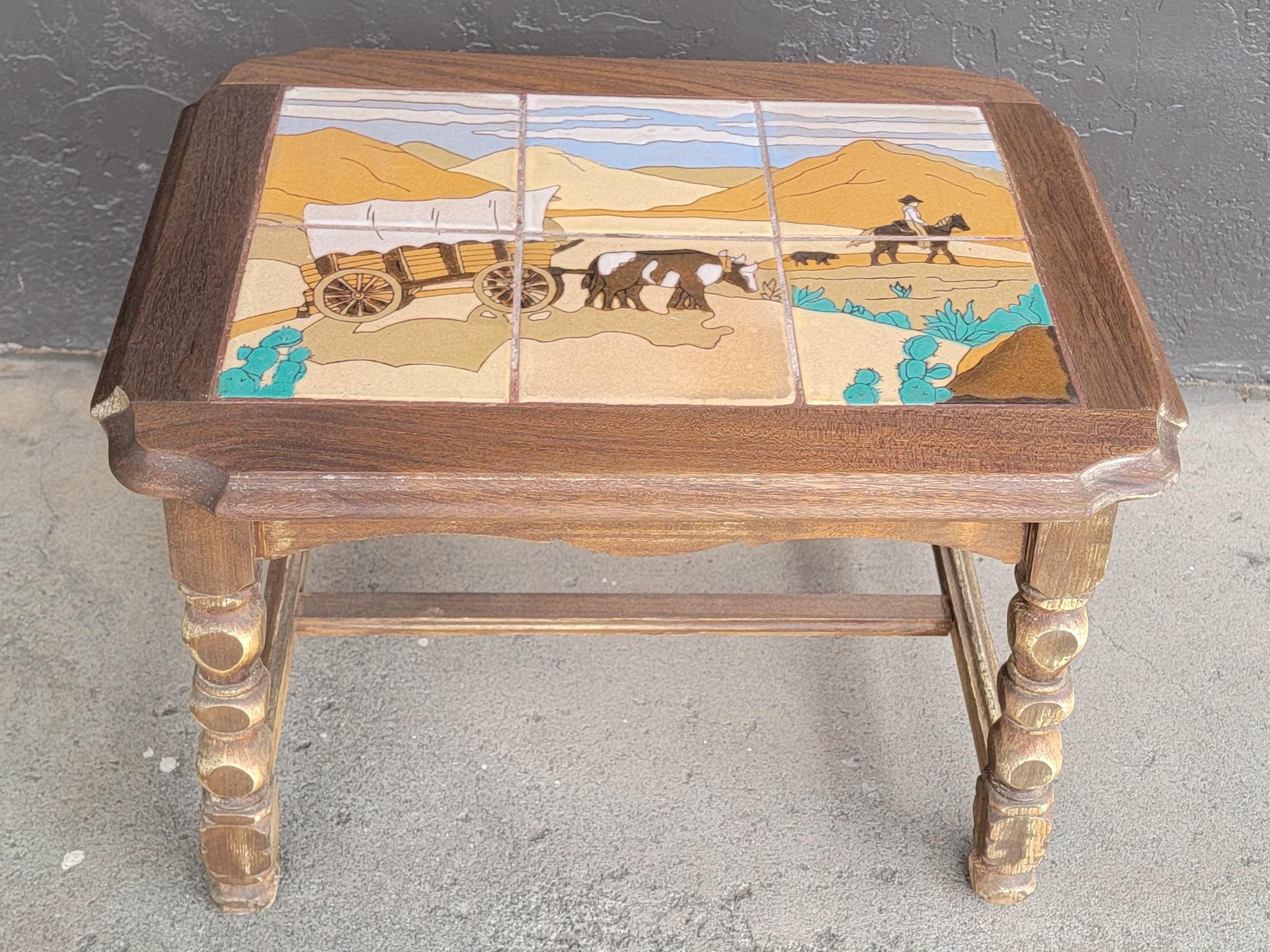 Table supérieure en carreaux à motif occidental de Taylor Tile, Californie. Circa. 1930's. Représentation d'un chariot couvert tiré par des bœufs dans un paysage désertique, un cow-boy à cheval avec un chien. Fond de cactus et de montagnes. Six